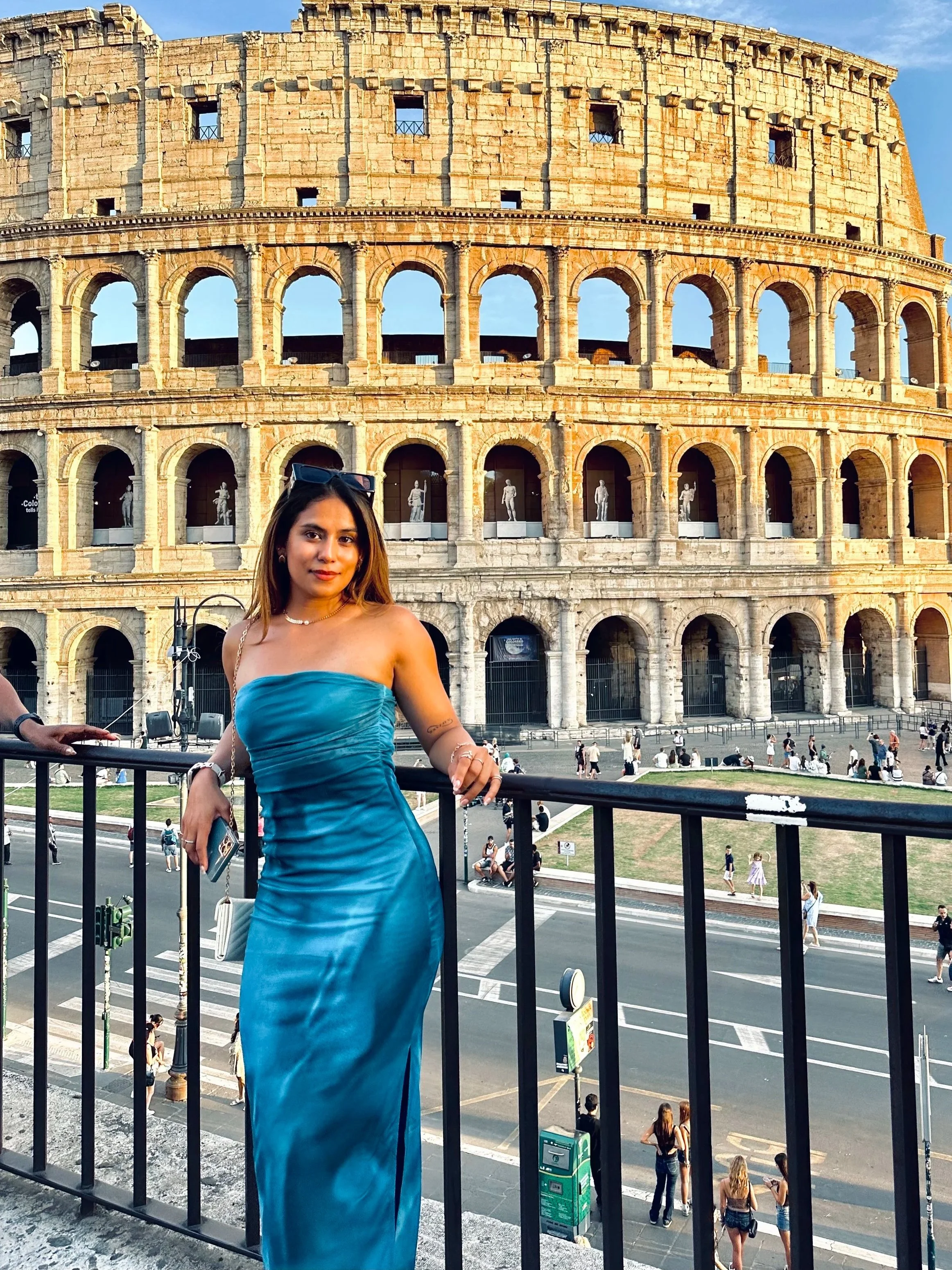 Rose in her blue dress posing in front of the colosseum