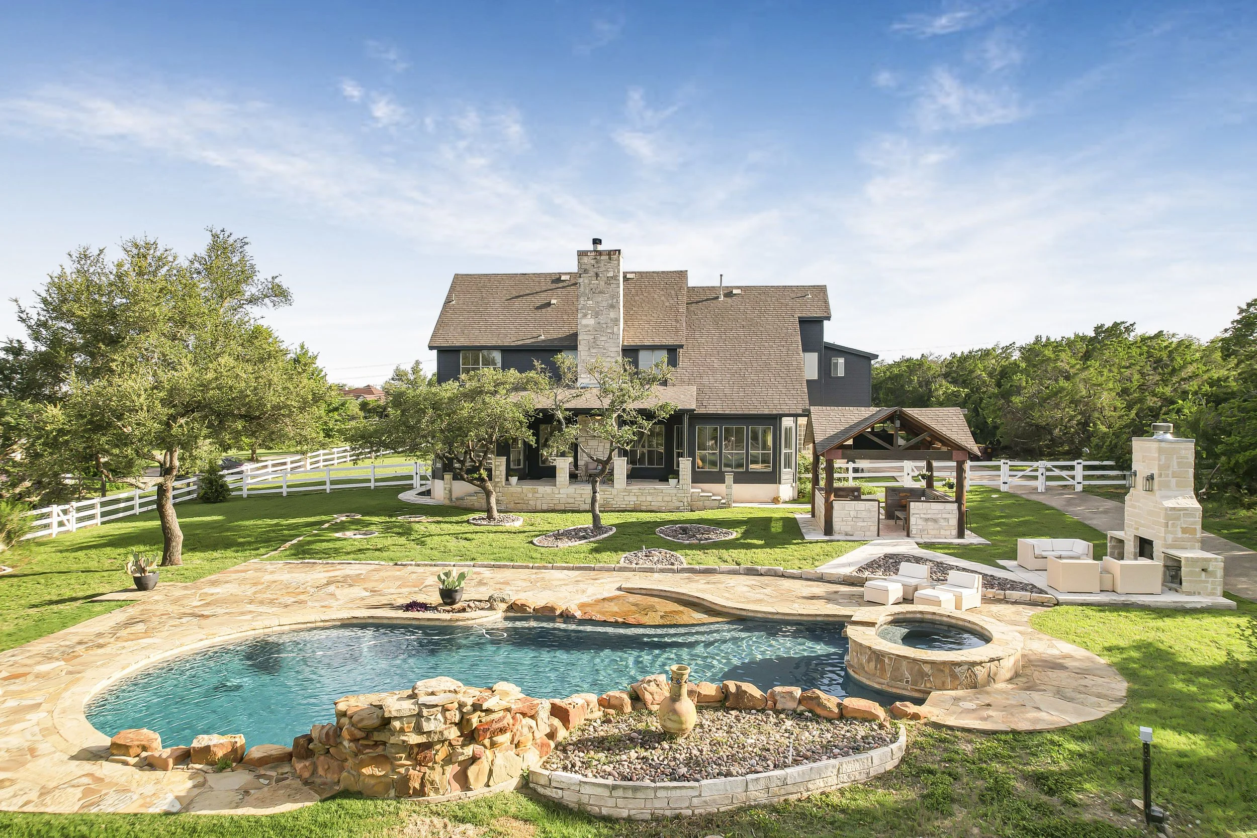 Ariel view of a home in Saddletree in Dripping Springs TX. With pool, hotub and fireplace.