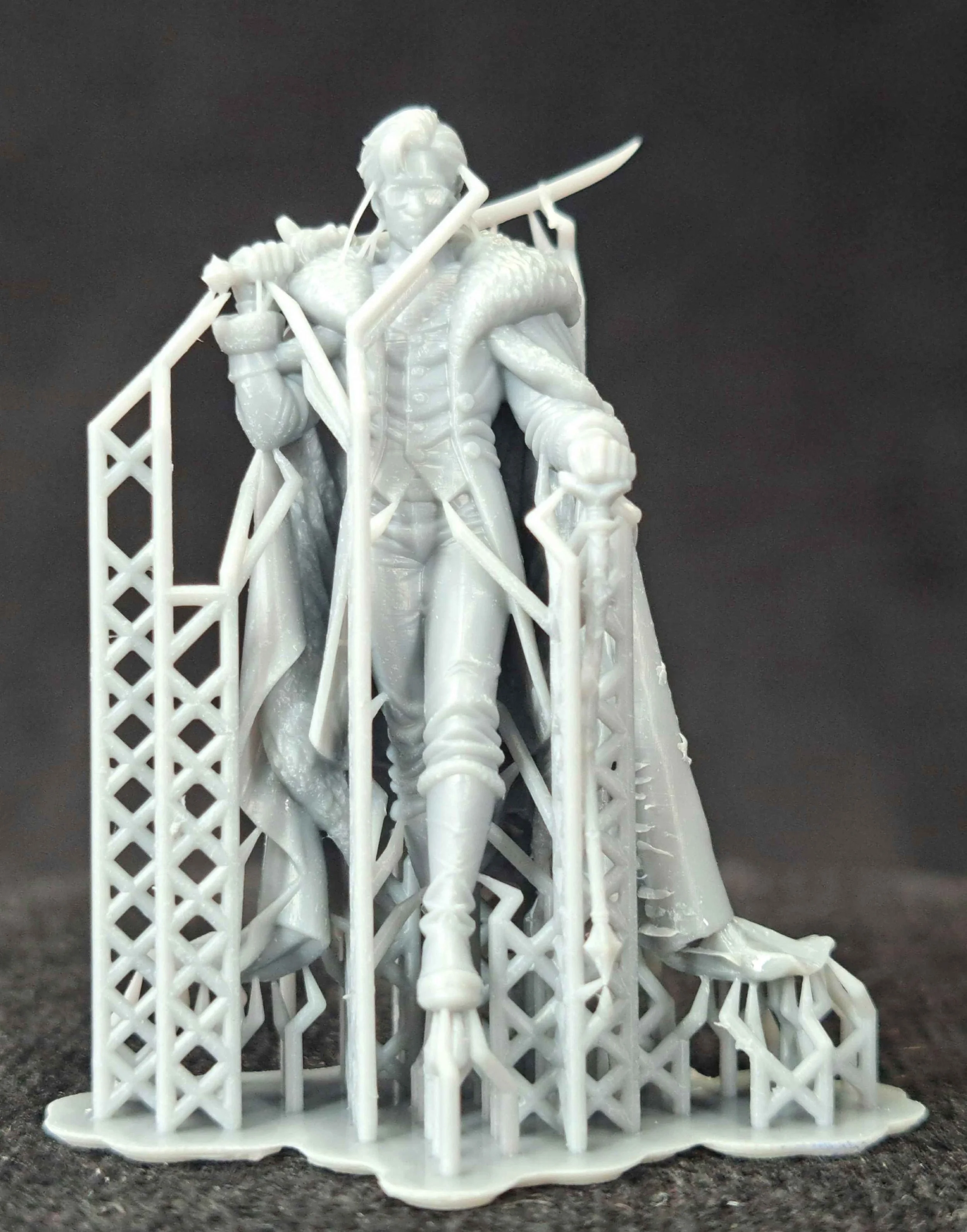 White 3D-printed figurine of a steampunk-style adventurer with a snake and a spear, standing in front of a scaffolding.