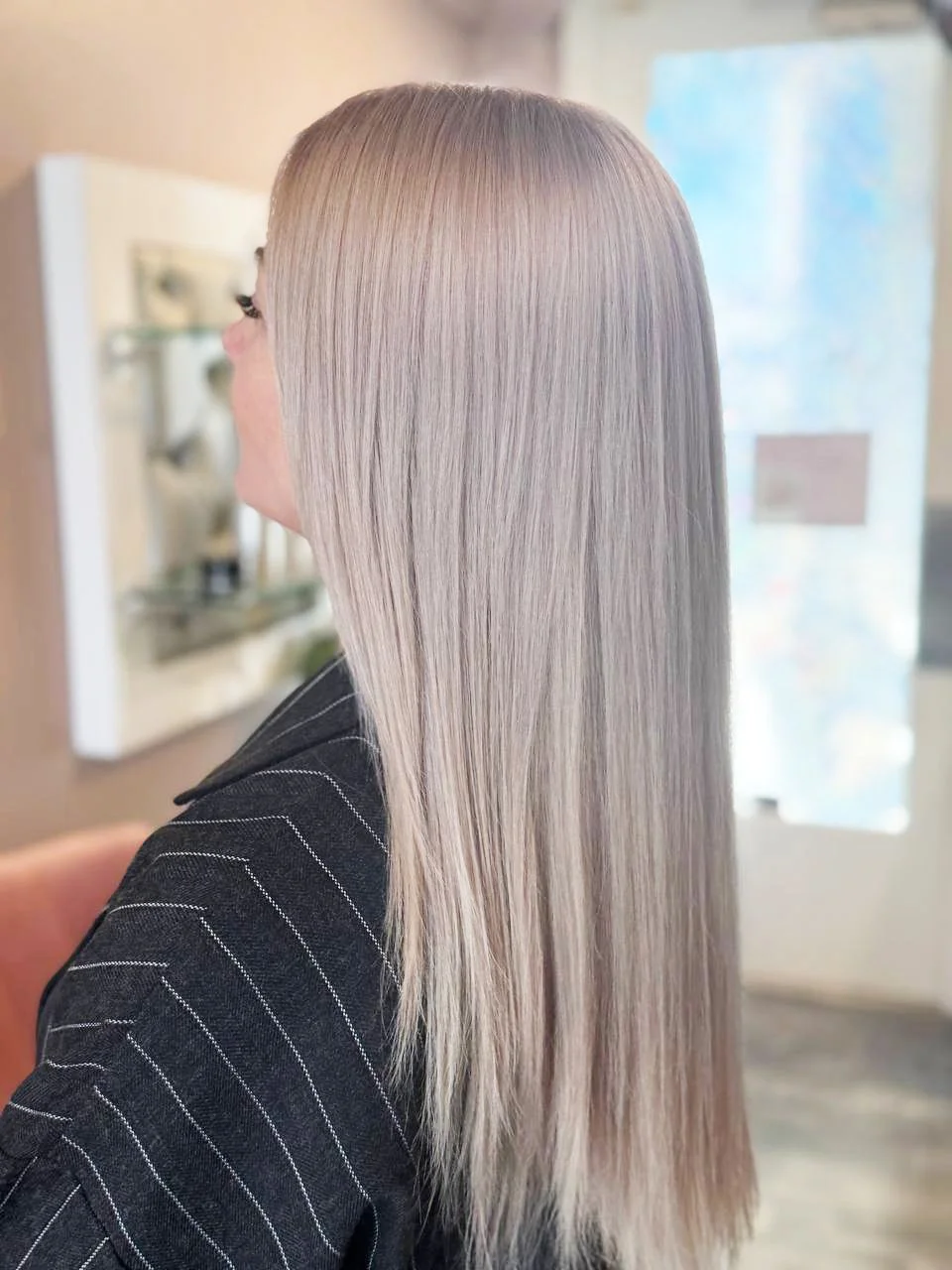 Woman with long, straight, platinum blonde hair in a salon.