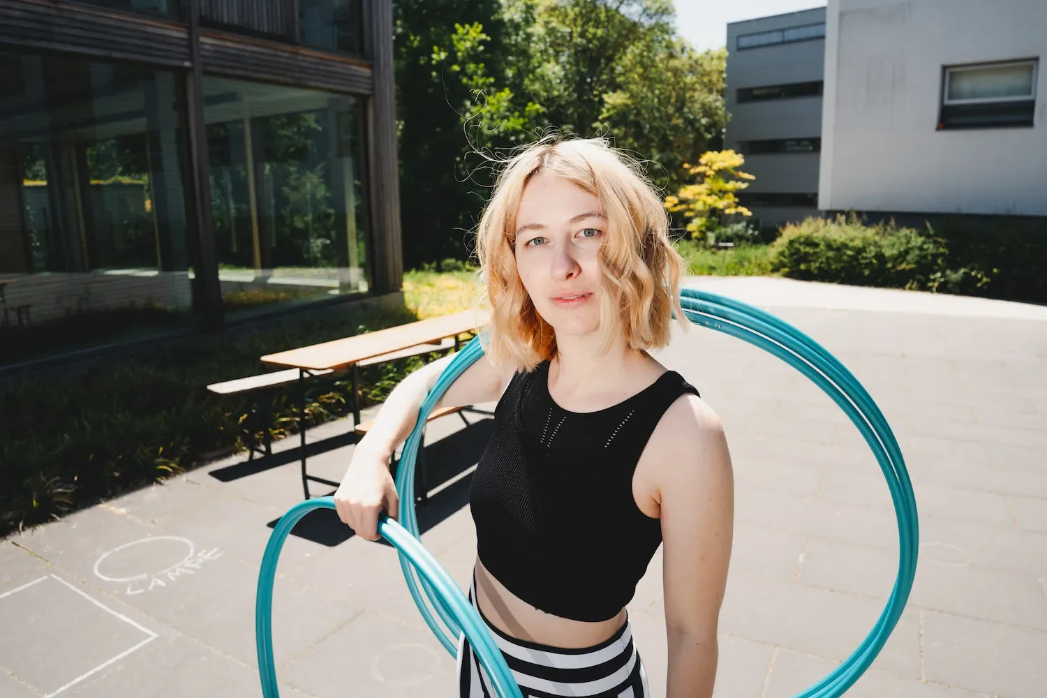 Hula-Hoop-Profi Fabia schaut in die Kamera und hält fünf Hula-Hoops