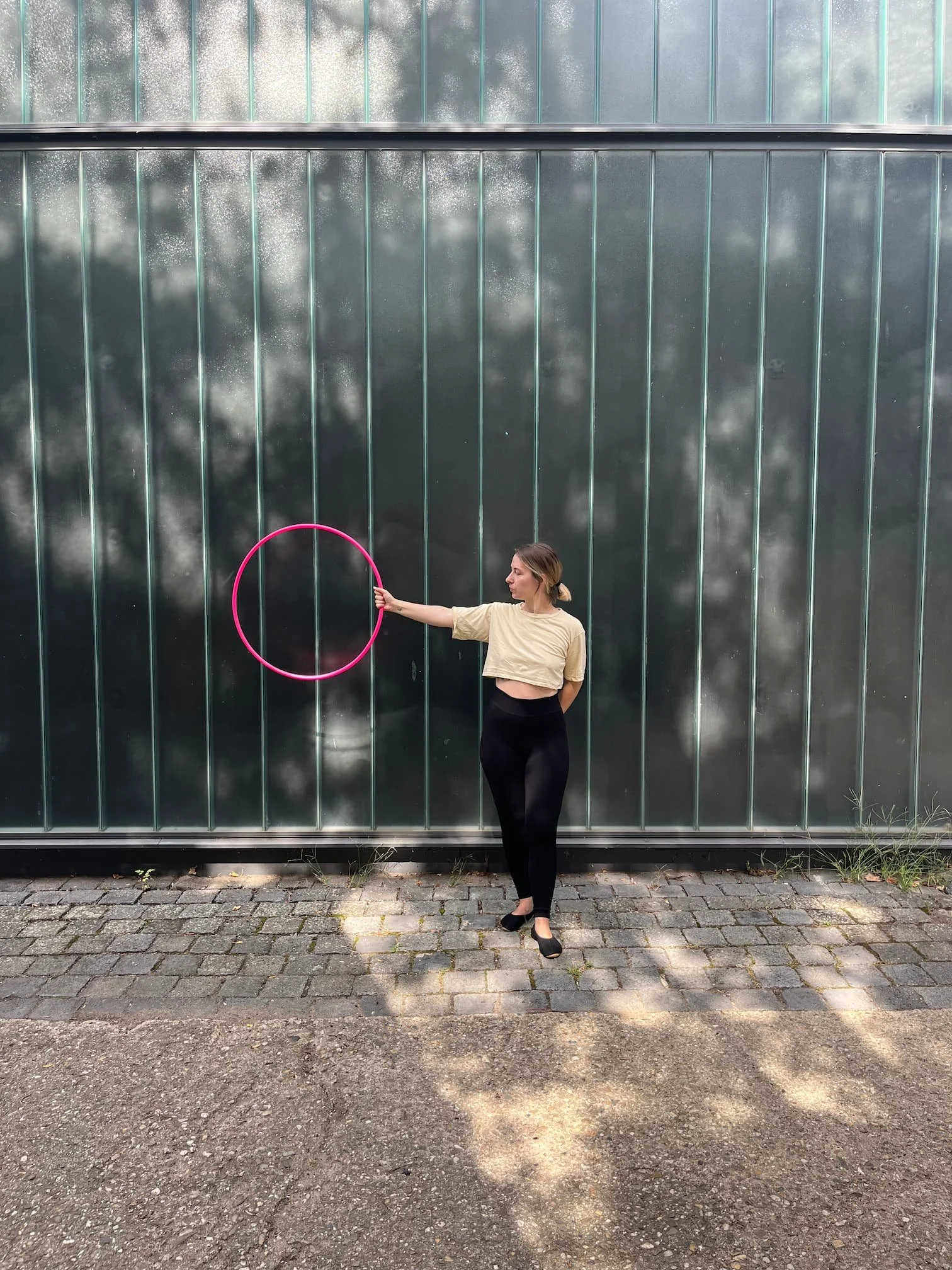 Hula-Hoop-Trainerin Fabia hält einen kleinen pinken Hula-Hoop-Reifen