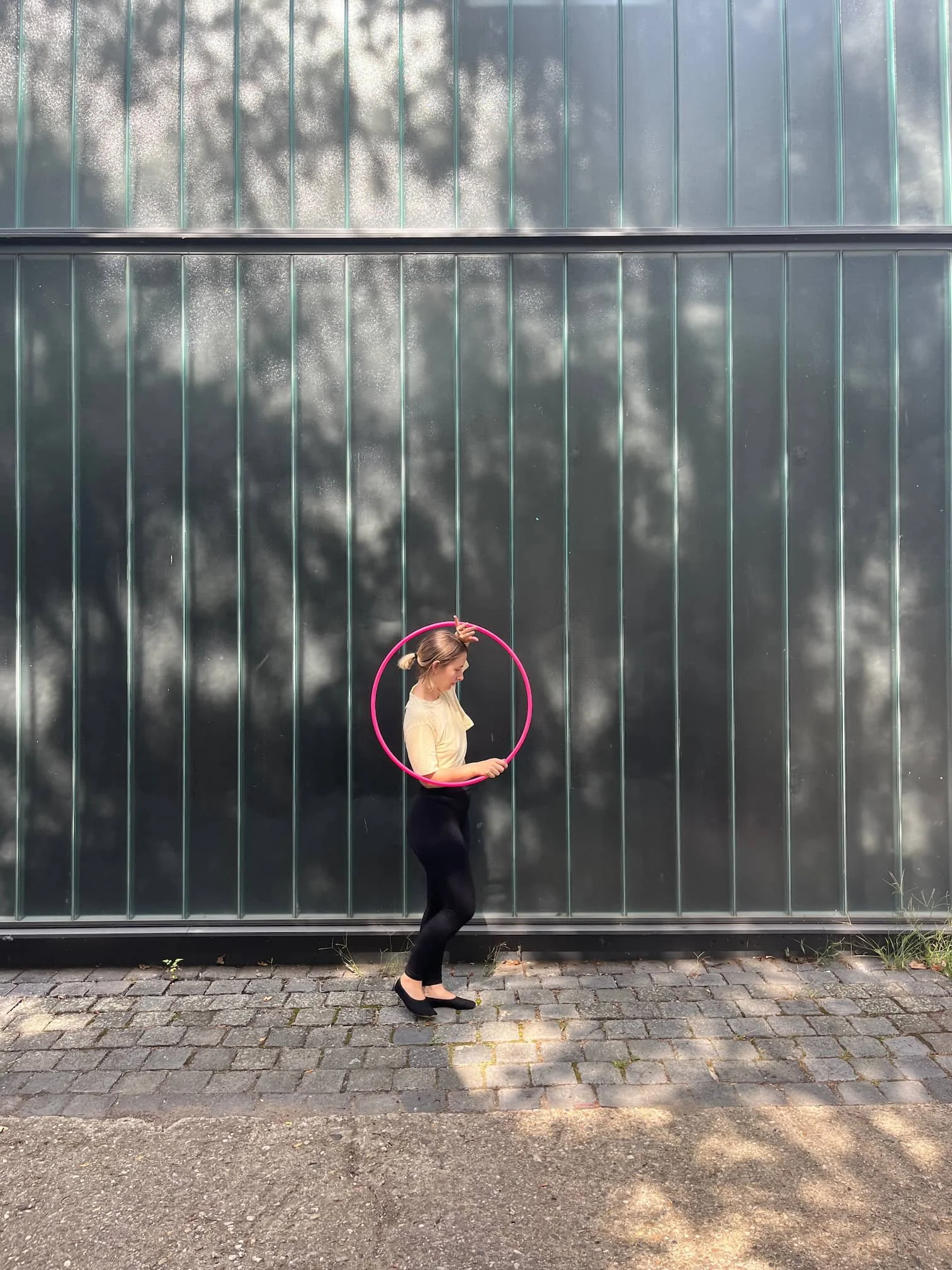 Hula-Hoop-Tänzerin macht einen Hula-Hoop-Trick mit einem pinken Reifen