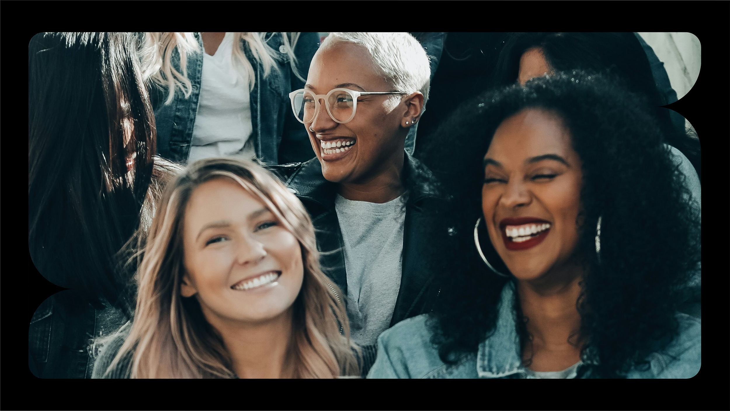 Group of diverse women smiling and laughing together, close-up photo.