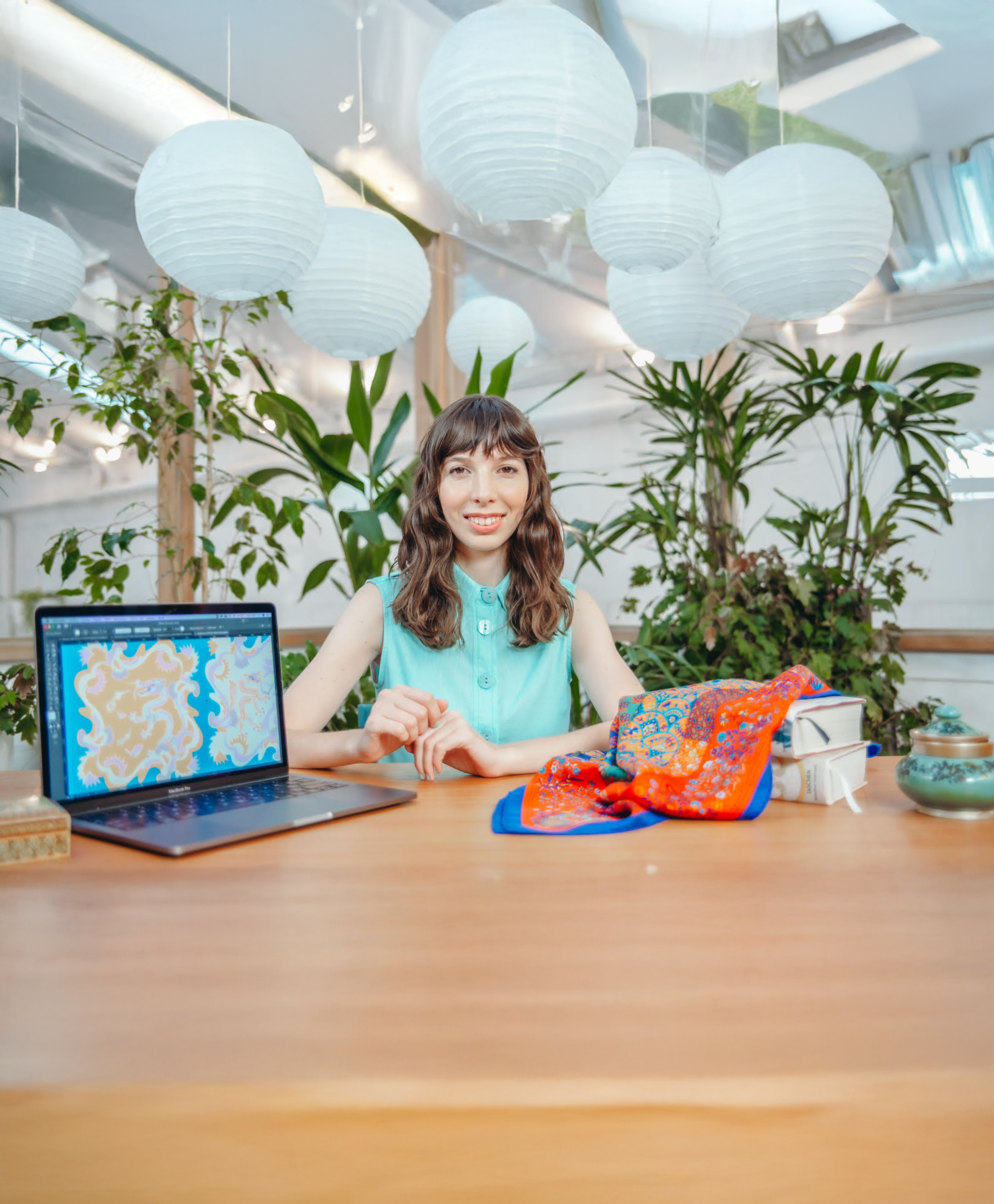 Diseñadora textil trabajando con materiales de estampados y laptop — Natasha Spitzer School of Design