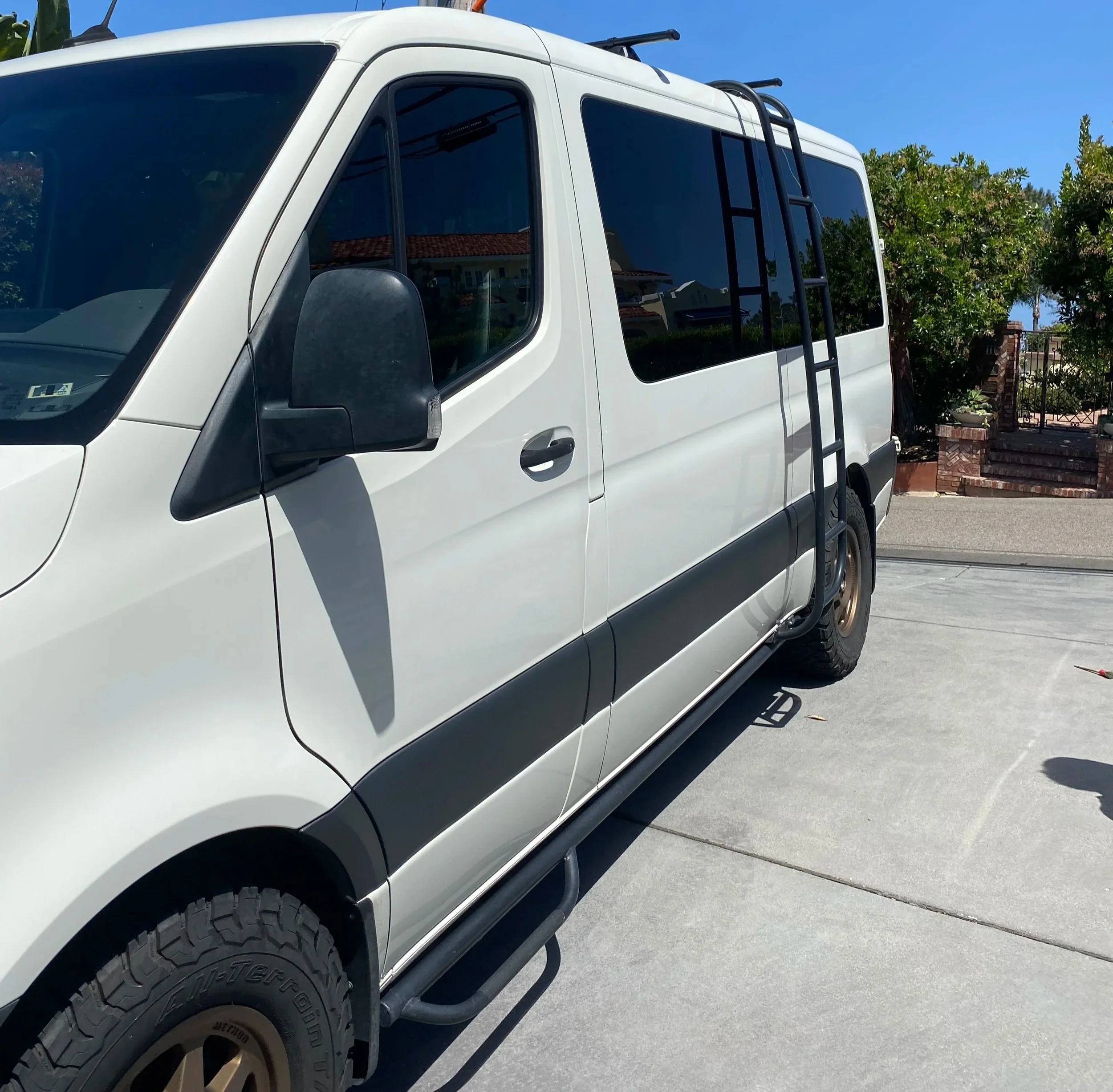 White cargo van with a black ladder on the side, parked on a driveway. After picture of a van during a detail in Del Mar, California.
