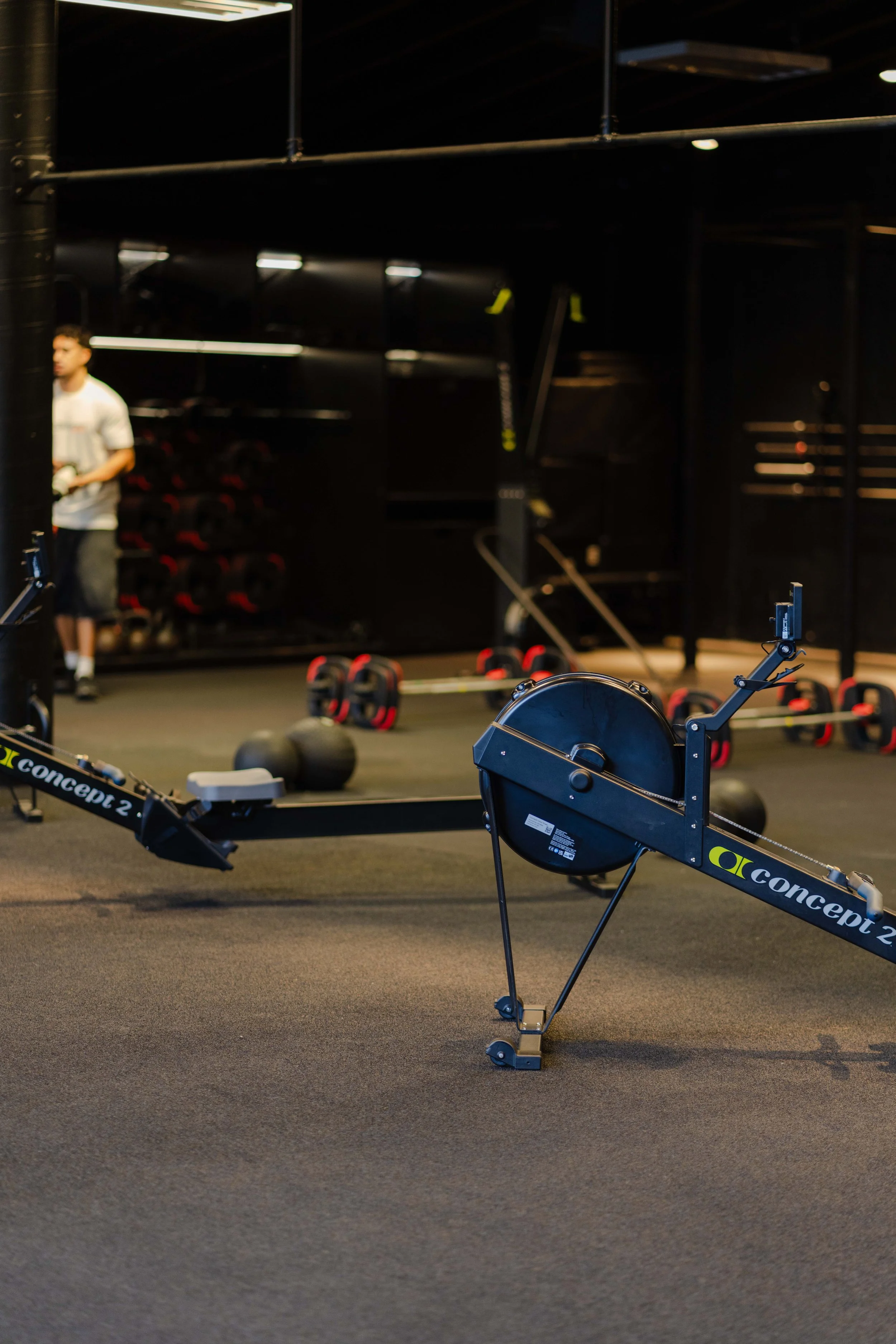 Fitness gym with Concept2 rowing machines and assorted weights in background