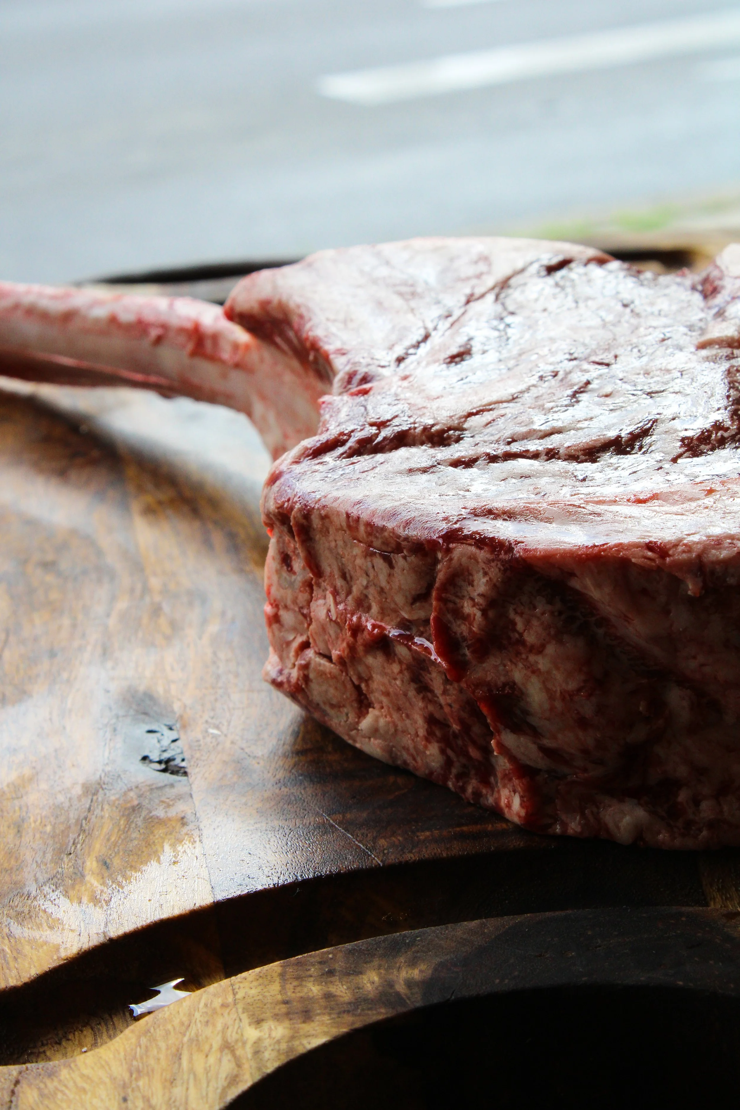 Raw, uncooked meat on a wooden cutting board.