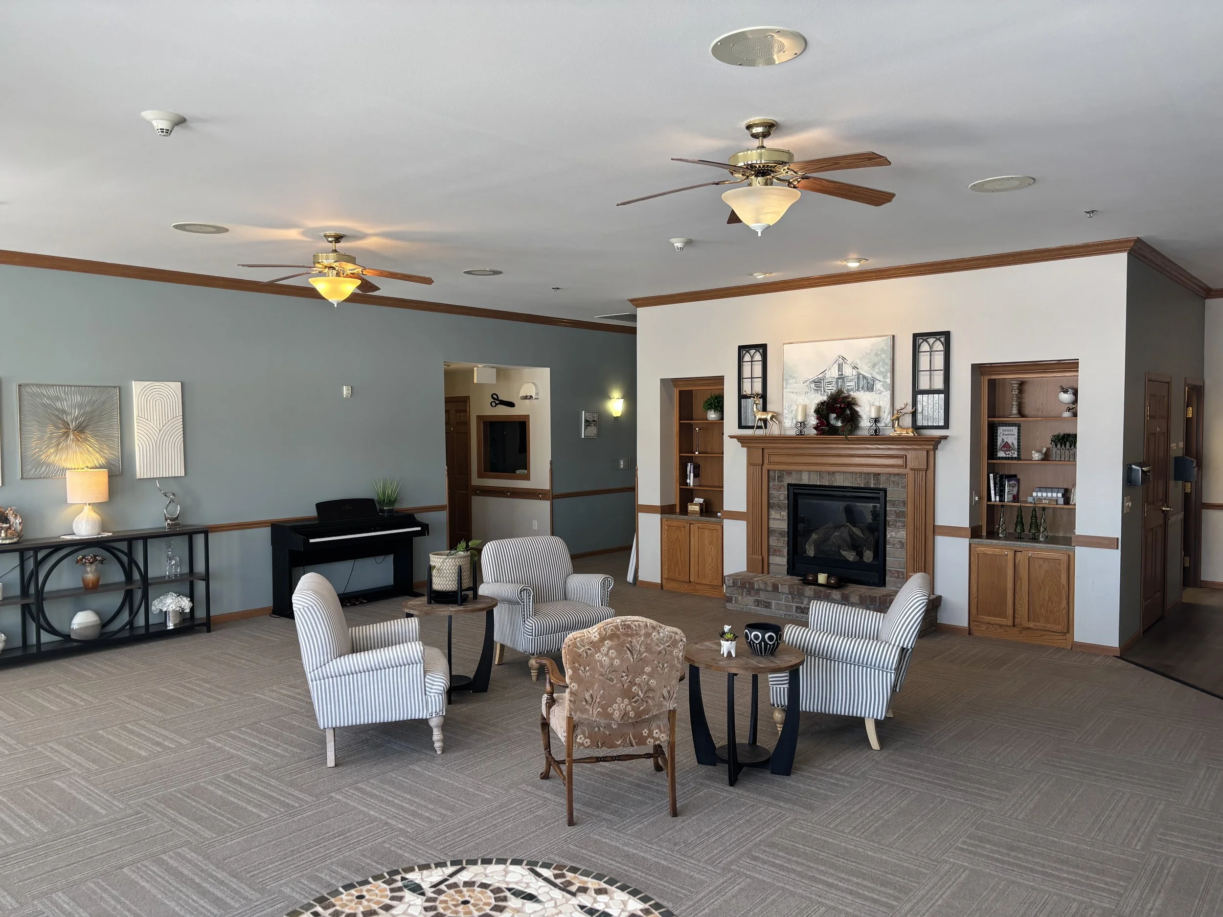 Spacious day room with a fireplace and resident seating at Havenfield Senior Living.