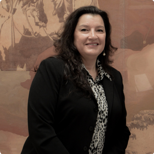 Teresa Dorsett, Commissioner, standing in front of a mural in black blazer and leopard print blouse.