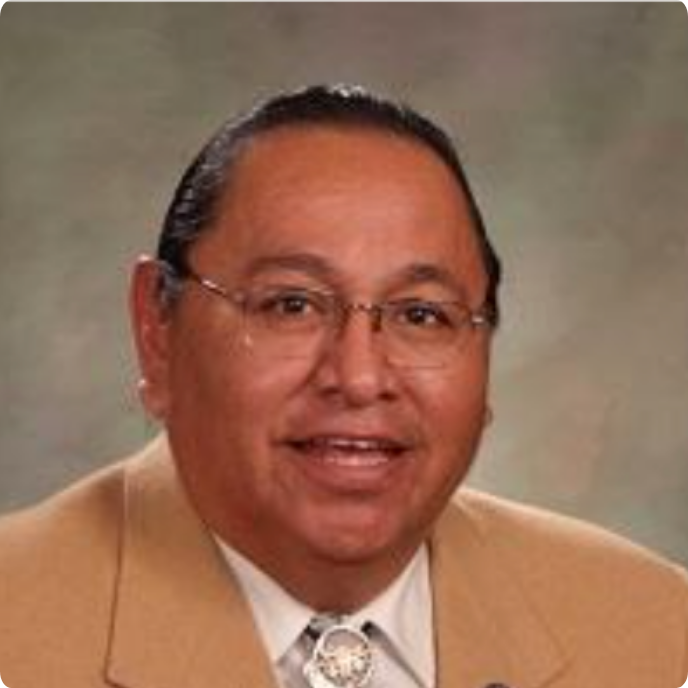 W. Pattrick Goggles, Board Chair, smiling at the camera in a tan suit and glasses.