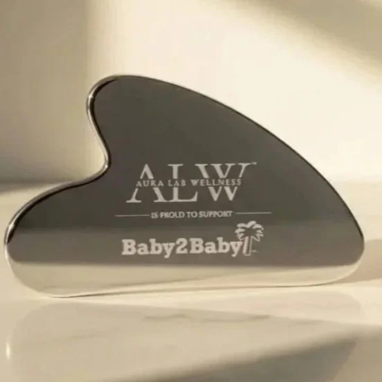 A heart-shaped mirror with text supporting Aura Lab Wellness and Baby2Baby