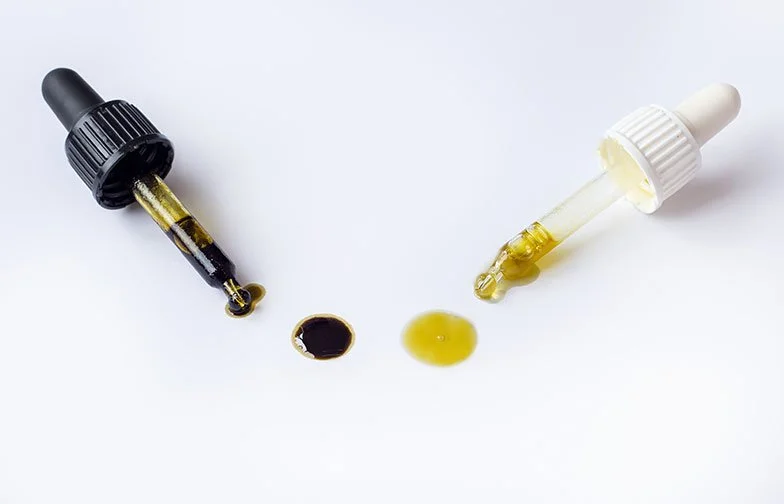 Aplicadores laboratoriais com amostra líquida de canabinoides, apresentados em ambiente neutro para uso técnico e farmacêutico.