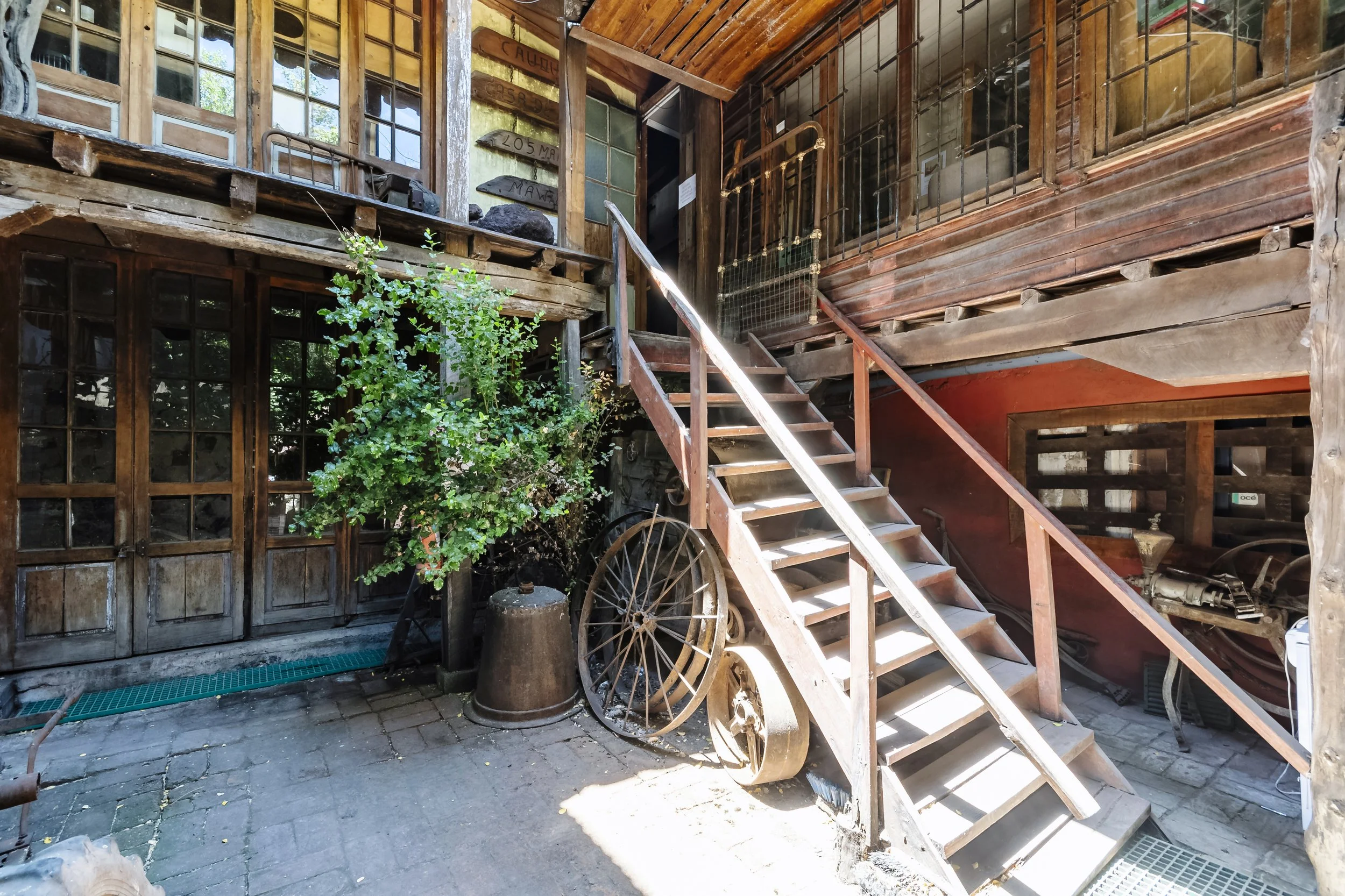Rustic wooden barn exterior and old farming machinery in a vineyard in Chilea, a stop during a Chilean Wine Uncovered wine country tour with Popi Planella.