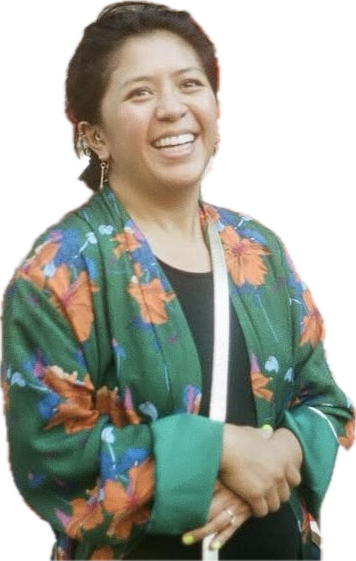 A woman smiling, wearing a green floral jacket and earrings, with short dark hair.