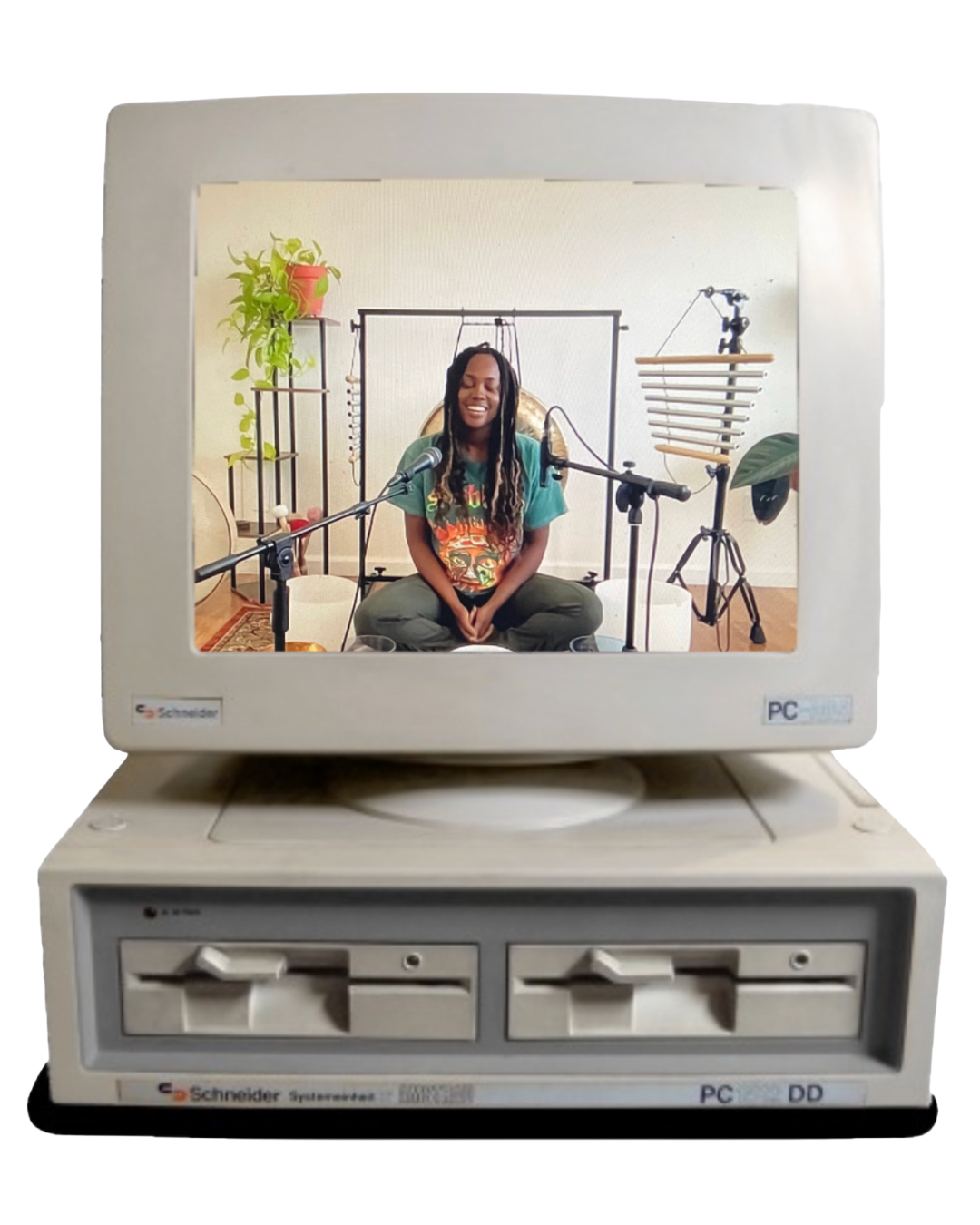 A woman sitting on the floor smiling with musical instruments and equipment around her, viewed through an old computer monitor frame.