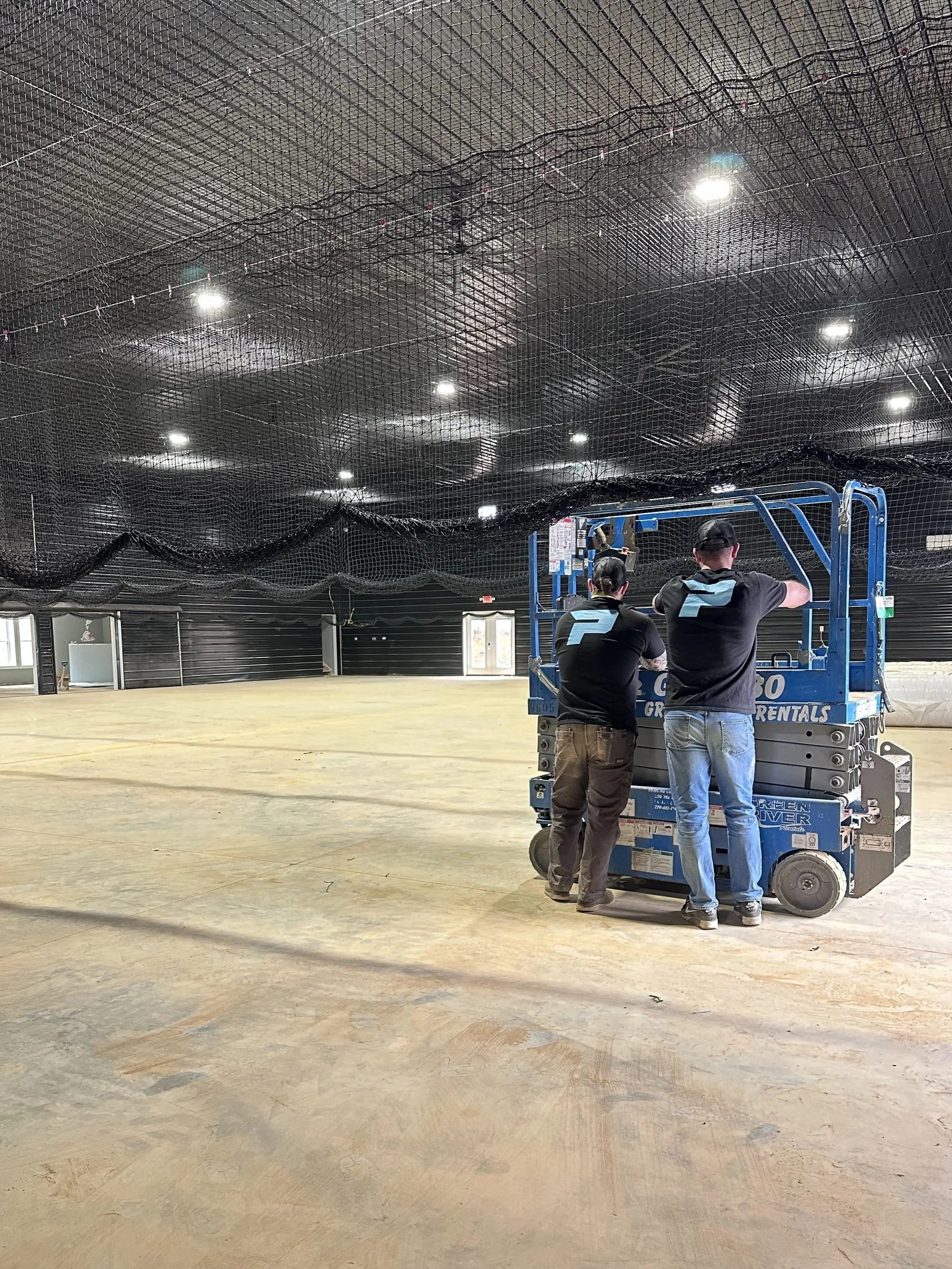 Owner and employee finished nets hanging and ready for turf installationnets