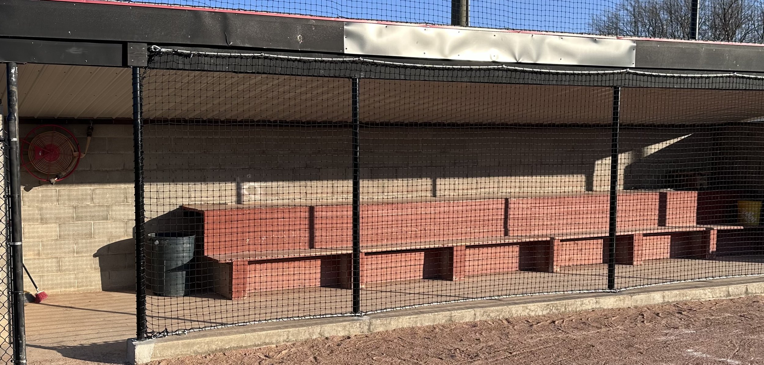 baseball softball dugout with nets on the front