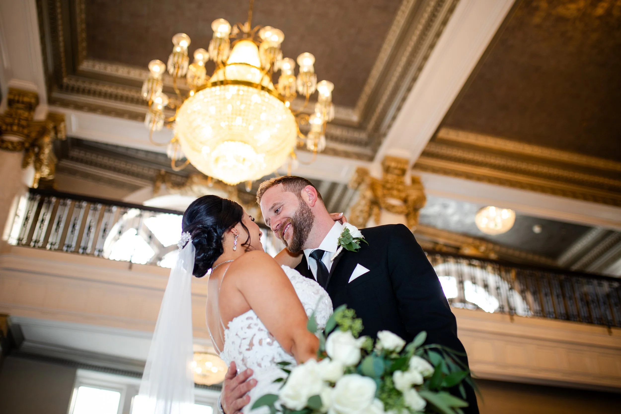 A bride and groom dipping for a photo in the lobby of Hotel Utica 