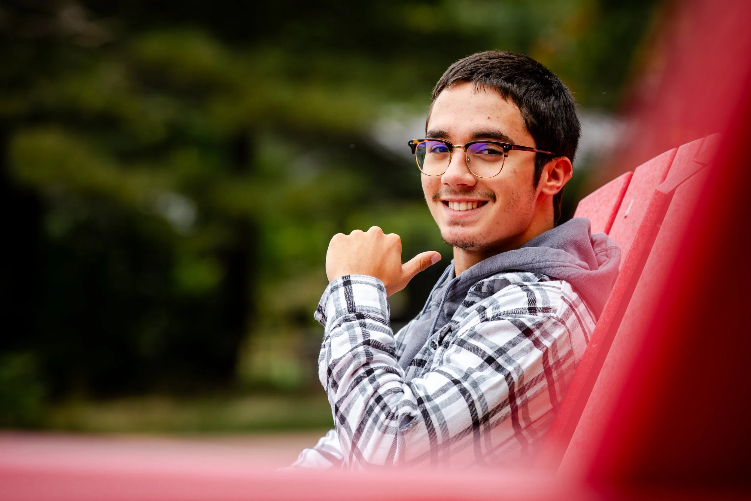 A senior shoot in the Adirondacks while sitting in a red chair