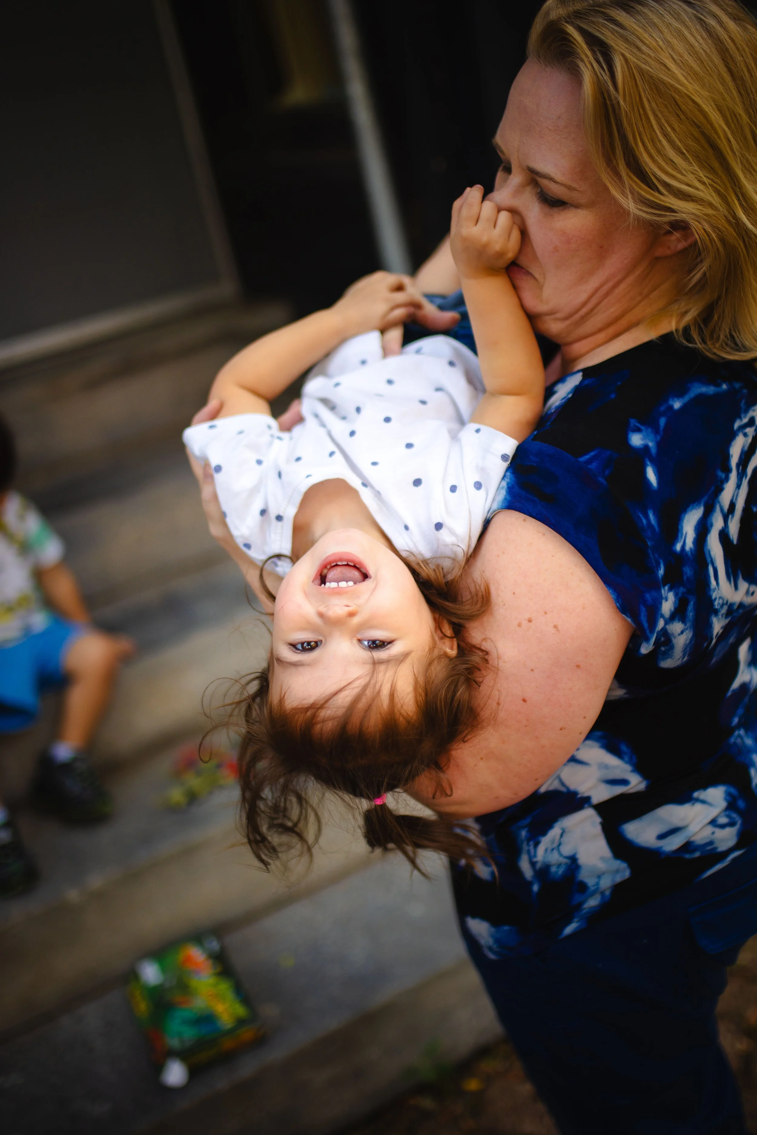 A little girl upside down while on a family shoot at the train station in Utica, NY