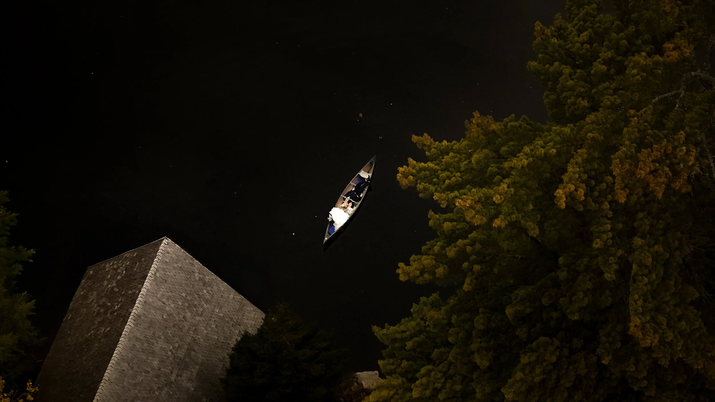 An aerial view of a canoe from a wedding in Raquette Lake at the Great Camp Sagamore