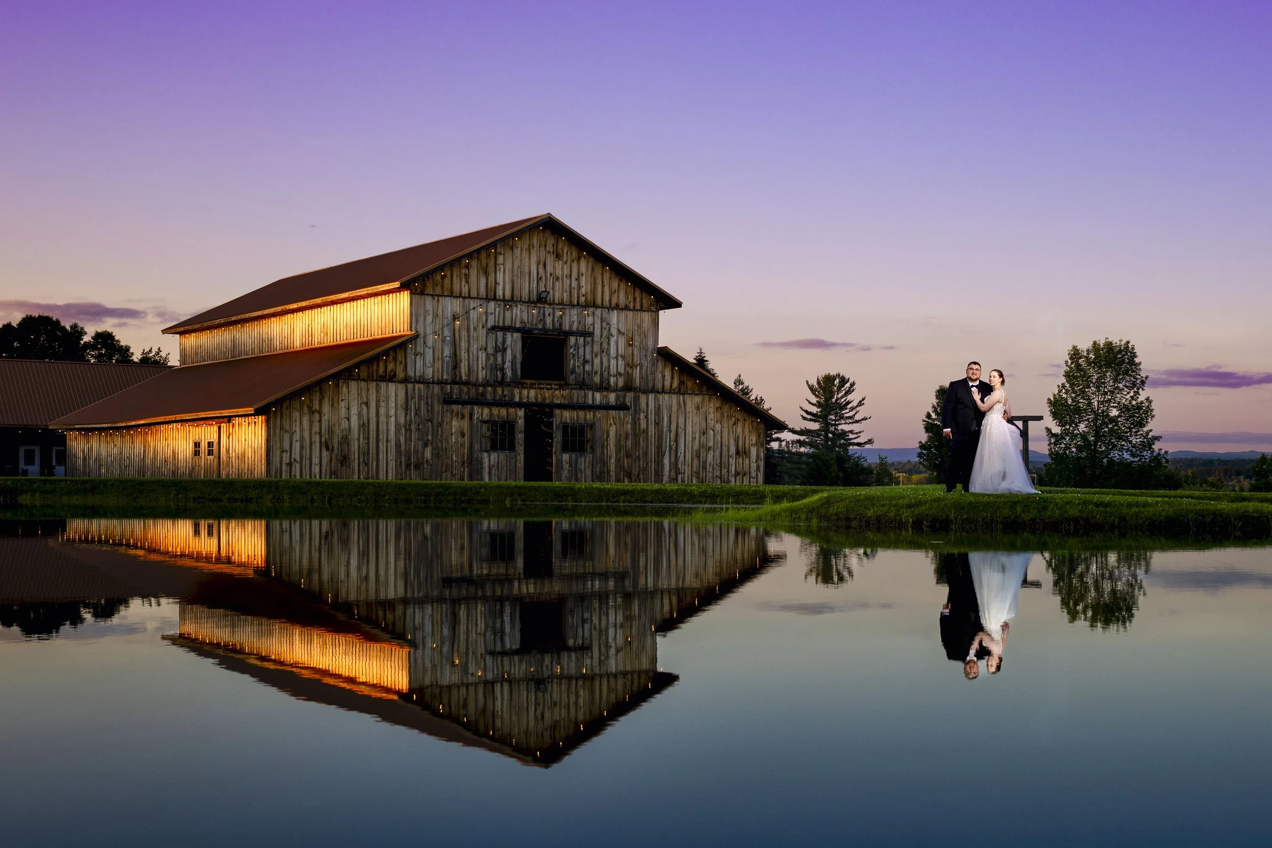 A bride and groom standing at the pond of Rustic Ties wedding in Dolgeville, NY 