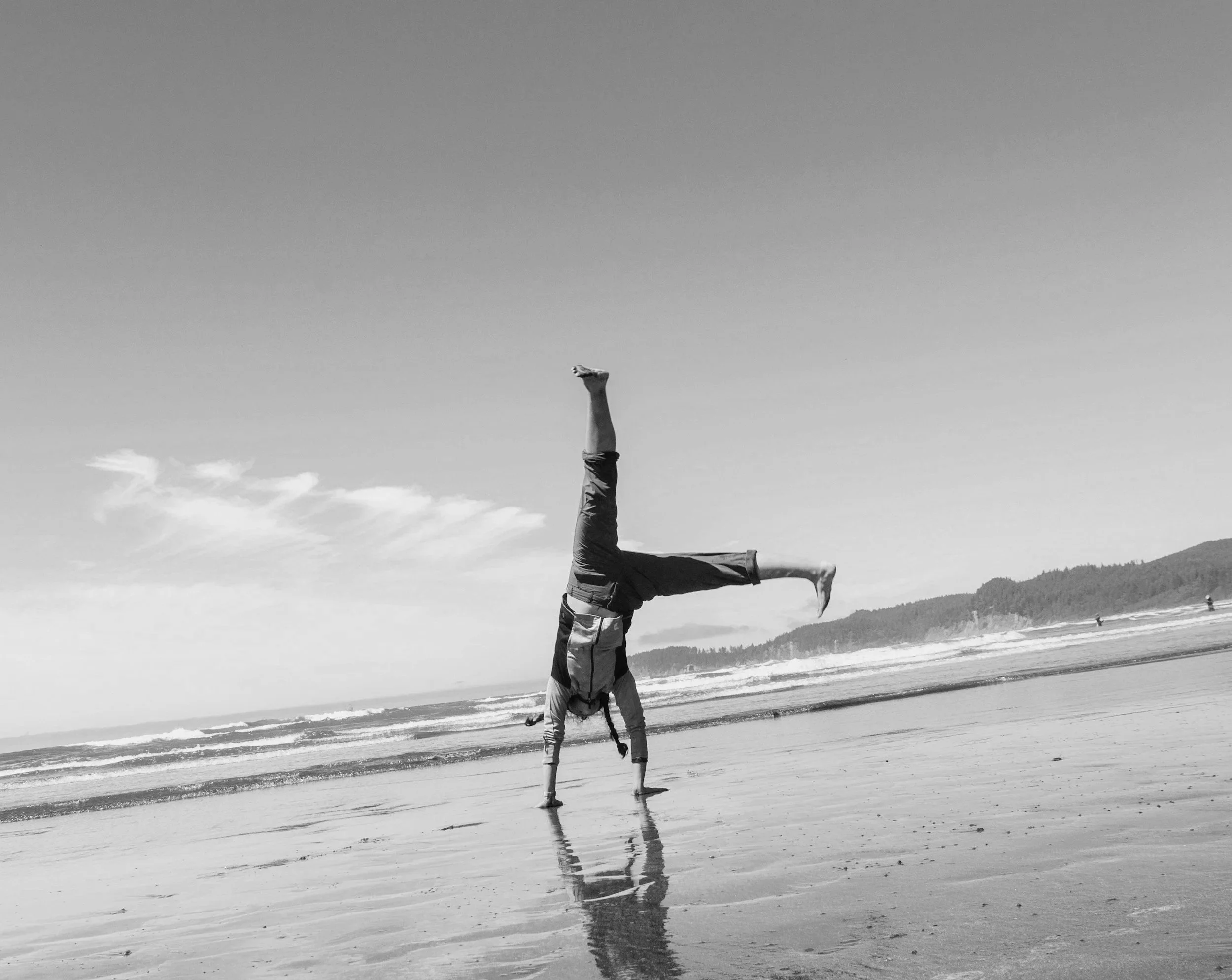 Person performing a handstand on the beach