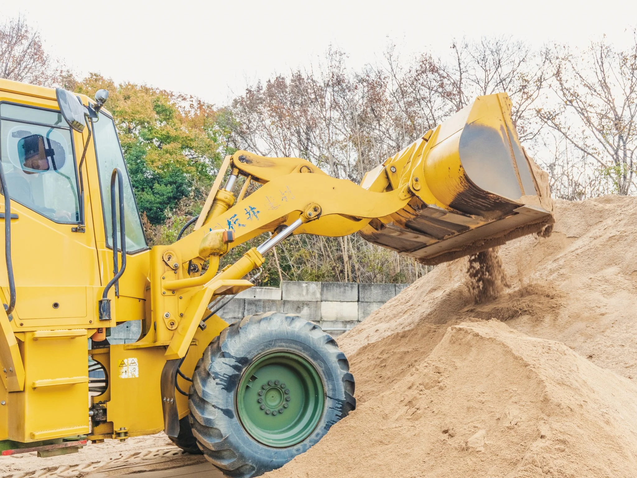 黄色いショベルカーが土を掘り起こしている様子