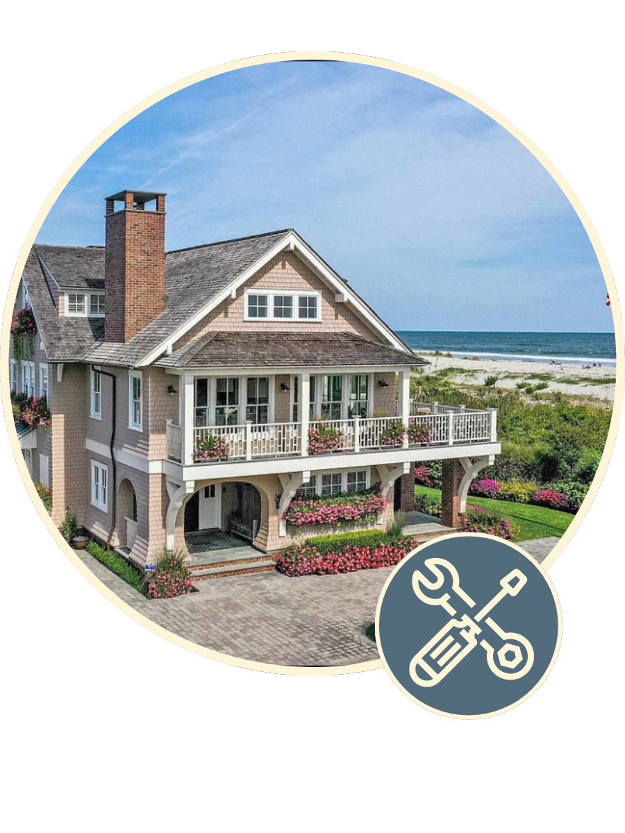 Front view of a two-story house with a porch, painted in light gray with white trim, and surrounded by a green lawn and small shrubs.