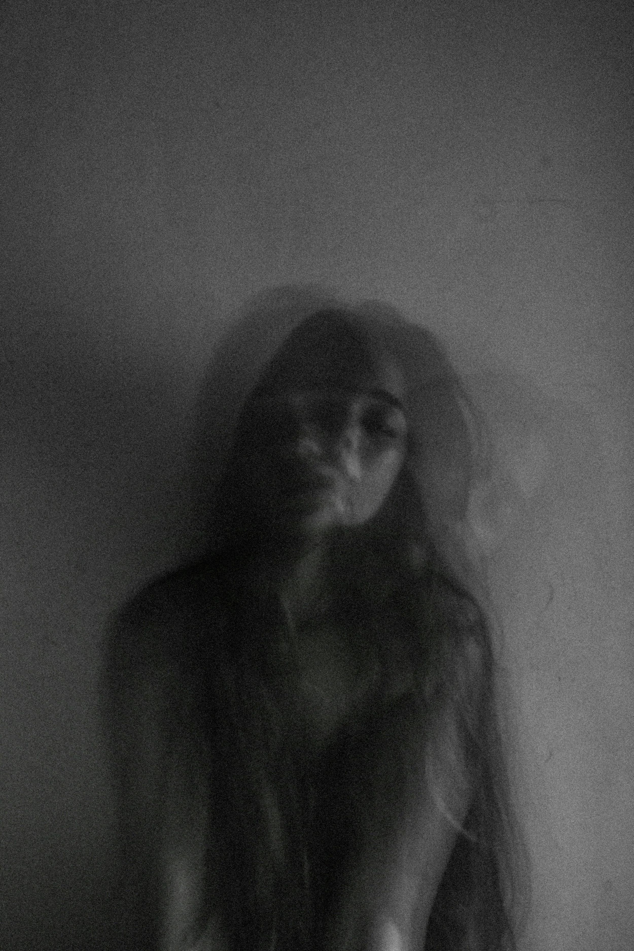 A multiple exposure photo of a woman with her eyes closed and a straight face.