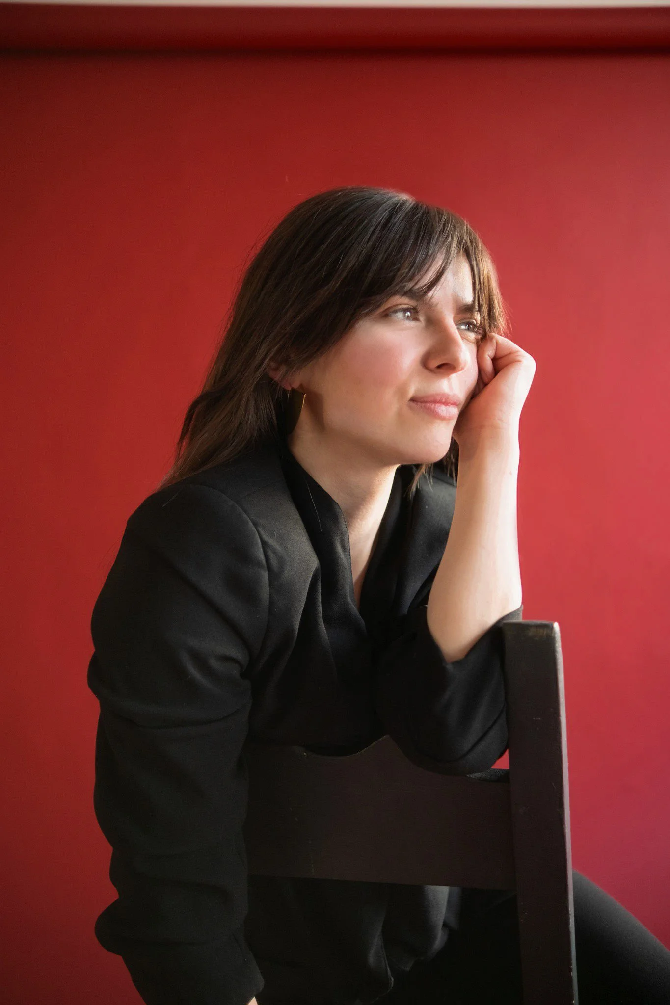 Portrait woman black blazer on red background
