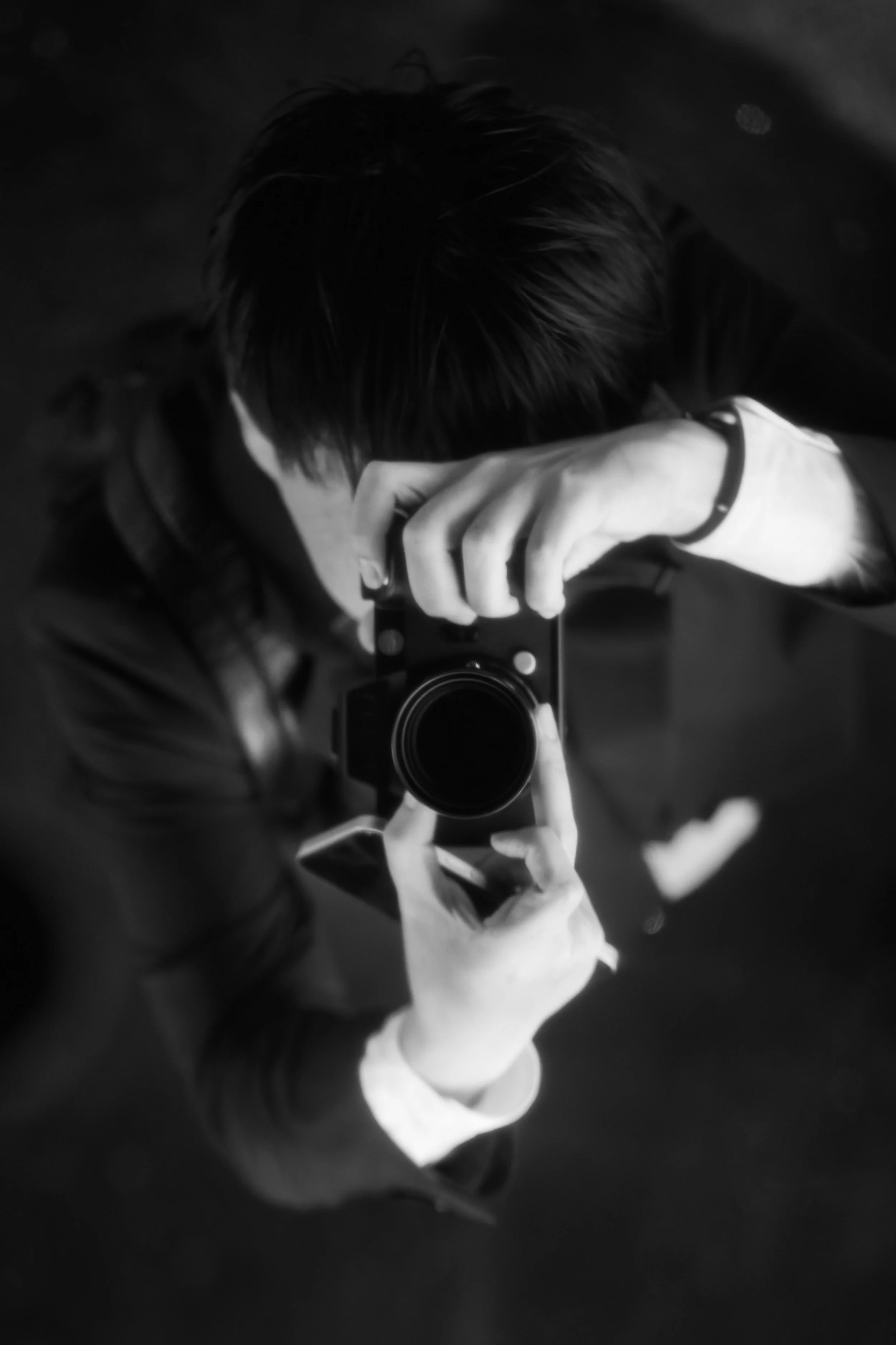 黒い服を着た人が上から見てカメラで自撮りをしている写真