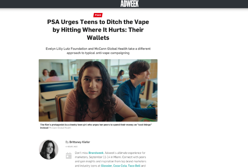 A girl and a boy sitting in a classroom, with the girl looking at the camera.