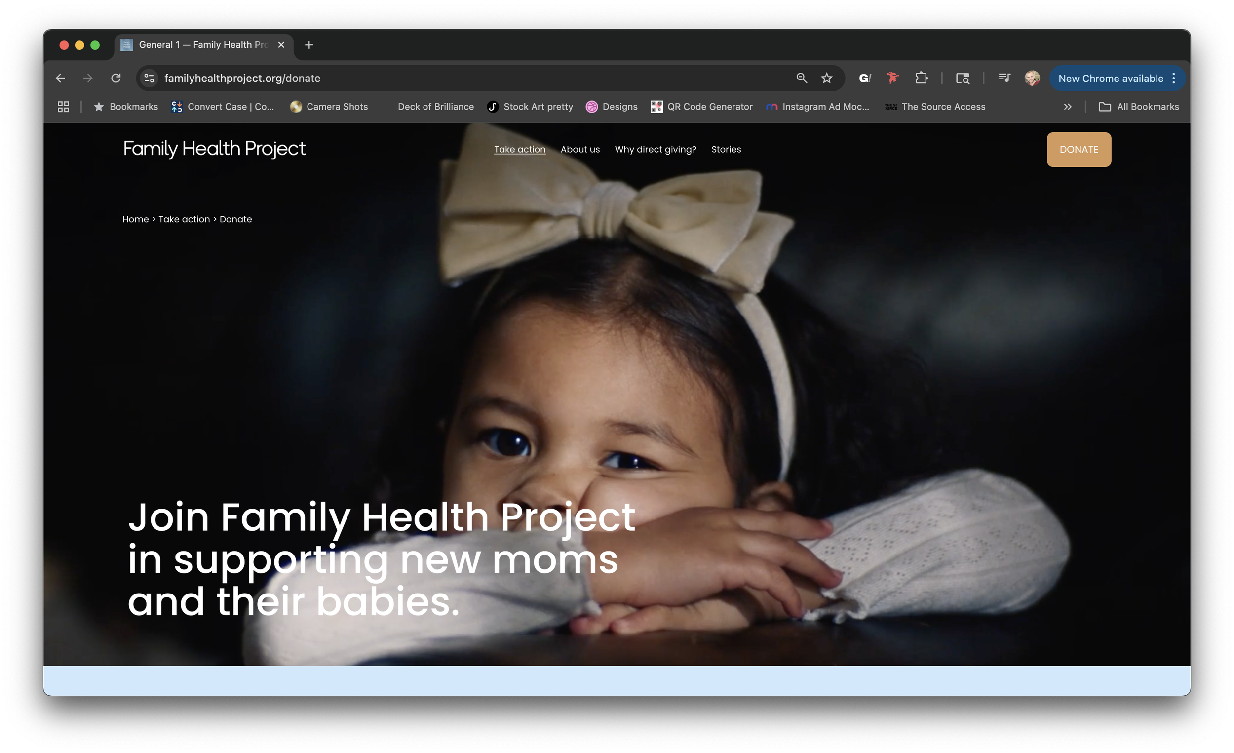 A smiling young girl with dark hair and a beige bow headband resting her head on her hands on a dark background