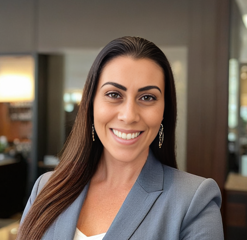 Professional woman with long dark hair smiling in an office setting