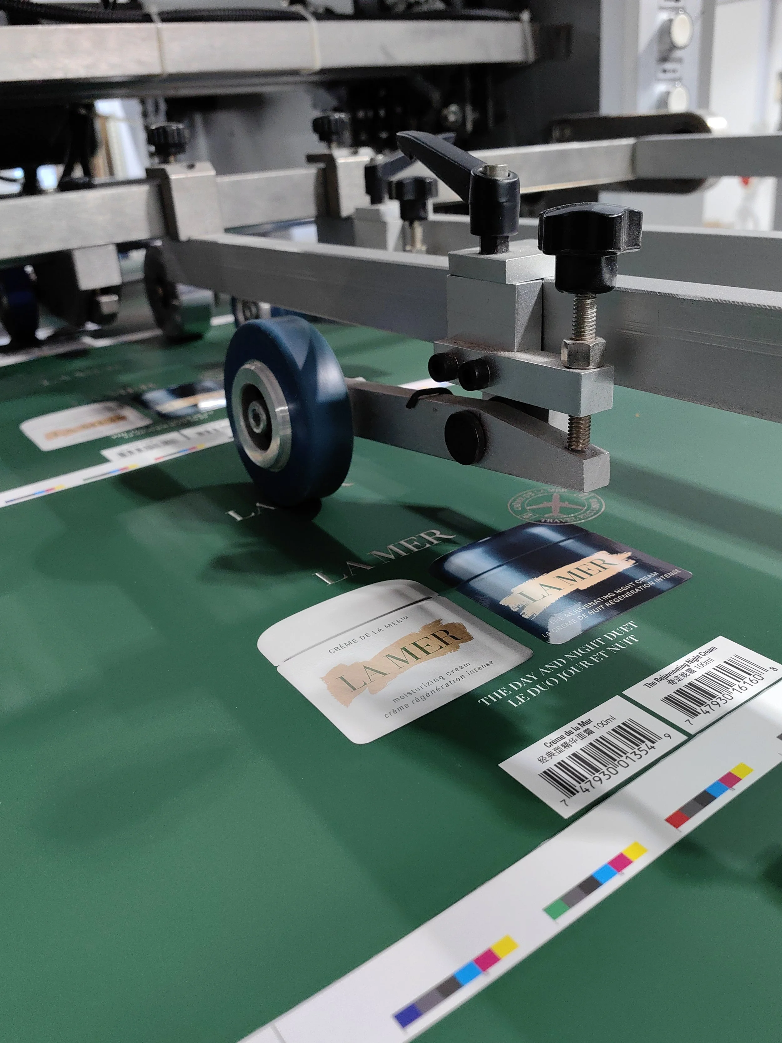 Automated production line showing La Mer BAC cartons being fed through die-cutting rollers with high-speed precision for accurate finishing.