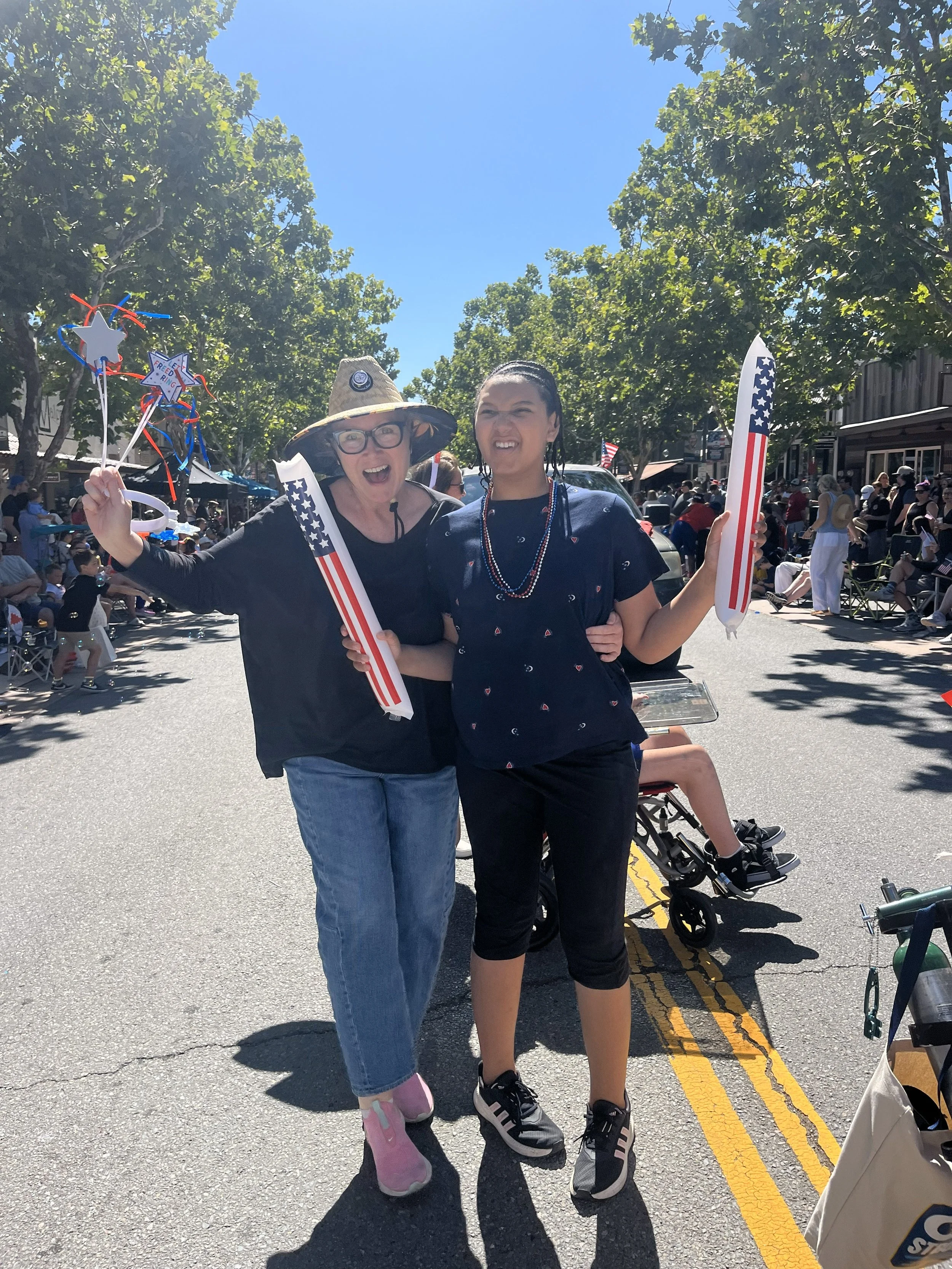 2 women walking in a city fourth of july parade