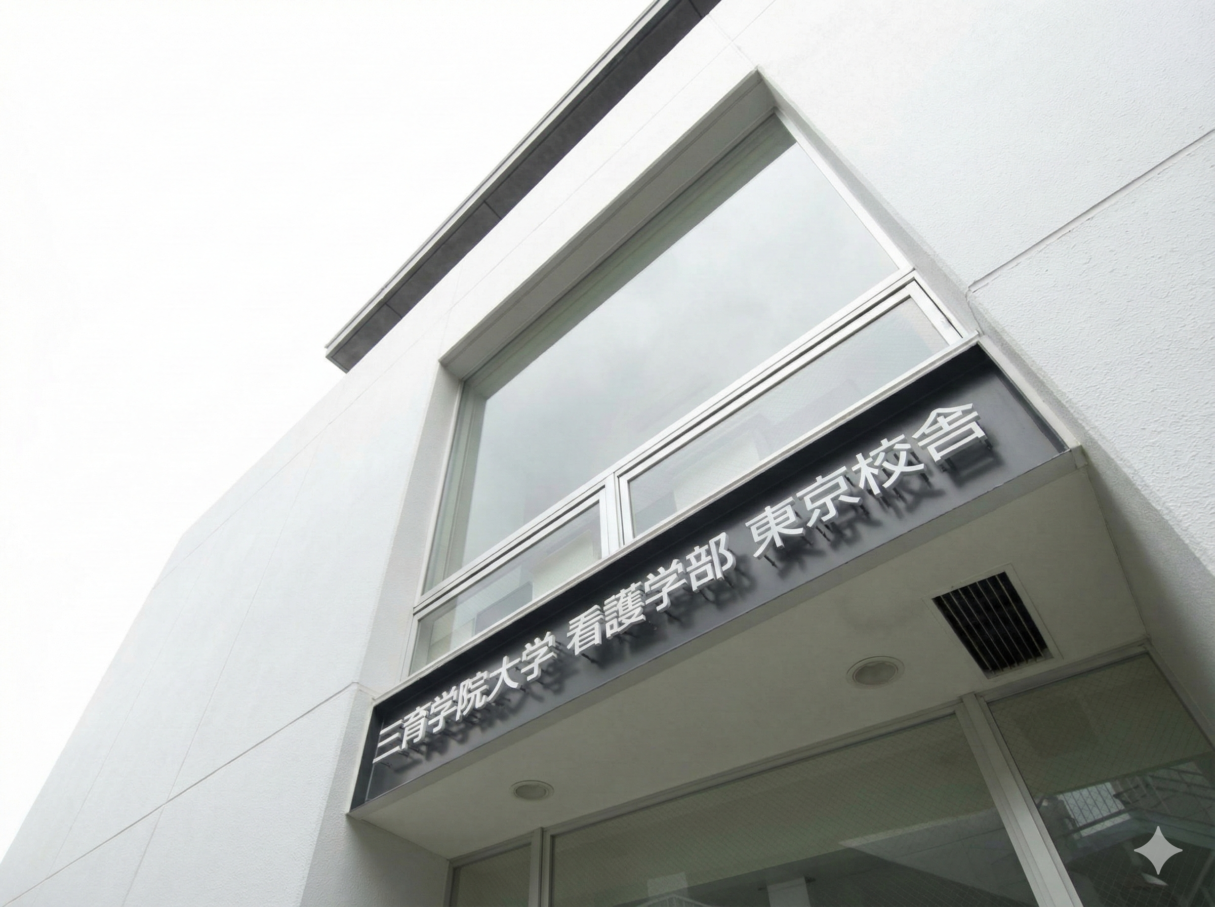 東京医科大学看護学部の看板がついた白い建物の側面の写真