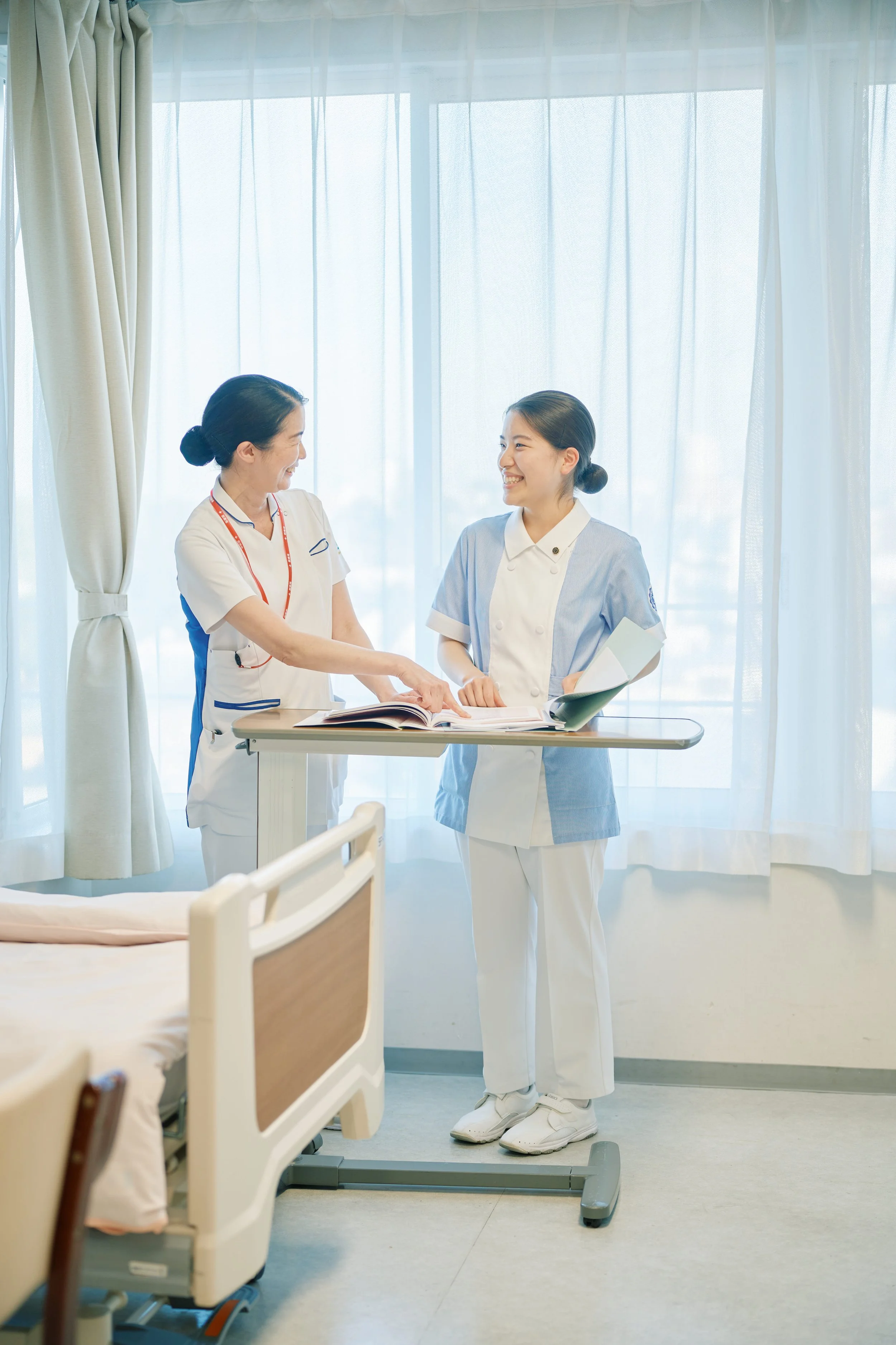 病室でおしゃべりをする看護師二人