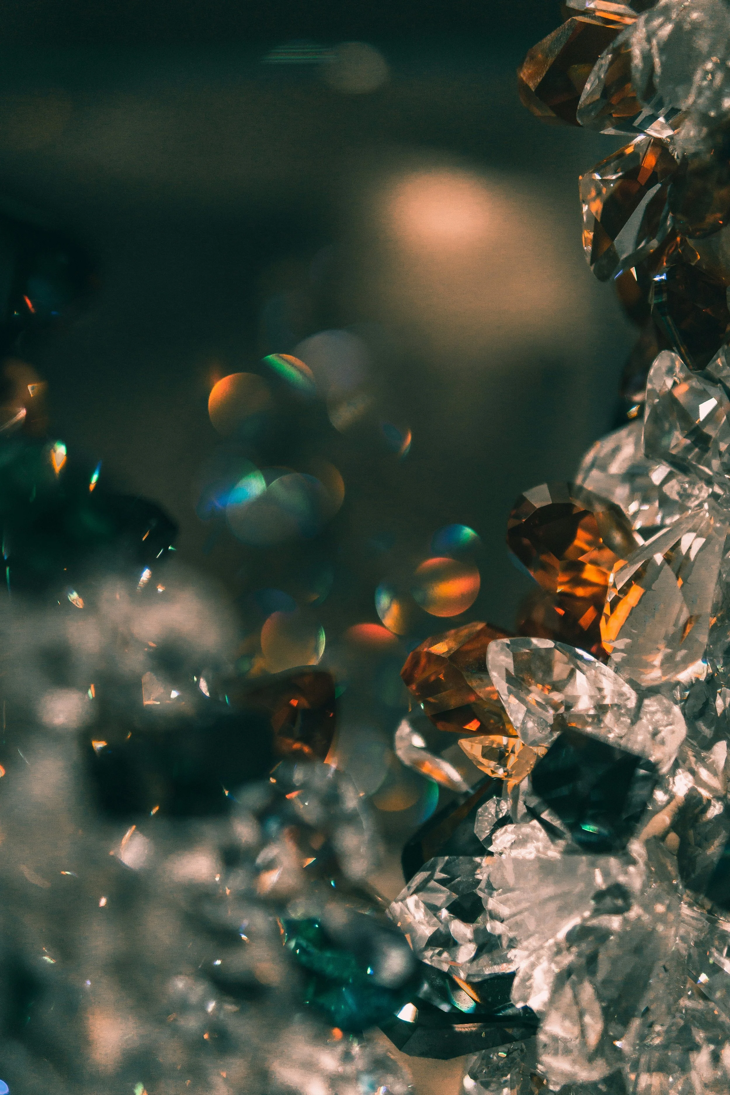 Close-up of shiny multicolored crystals and beads with reflections and bokeh effects.