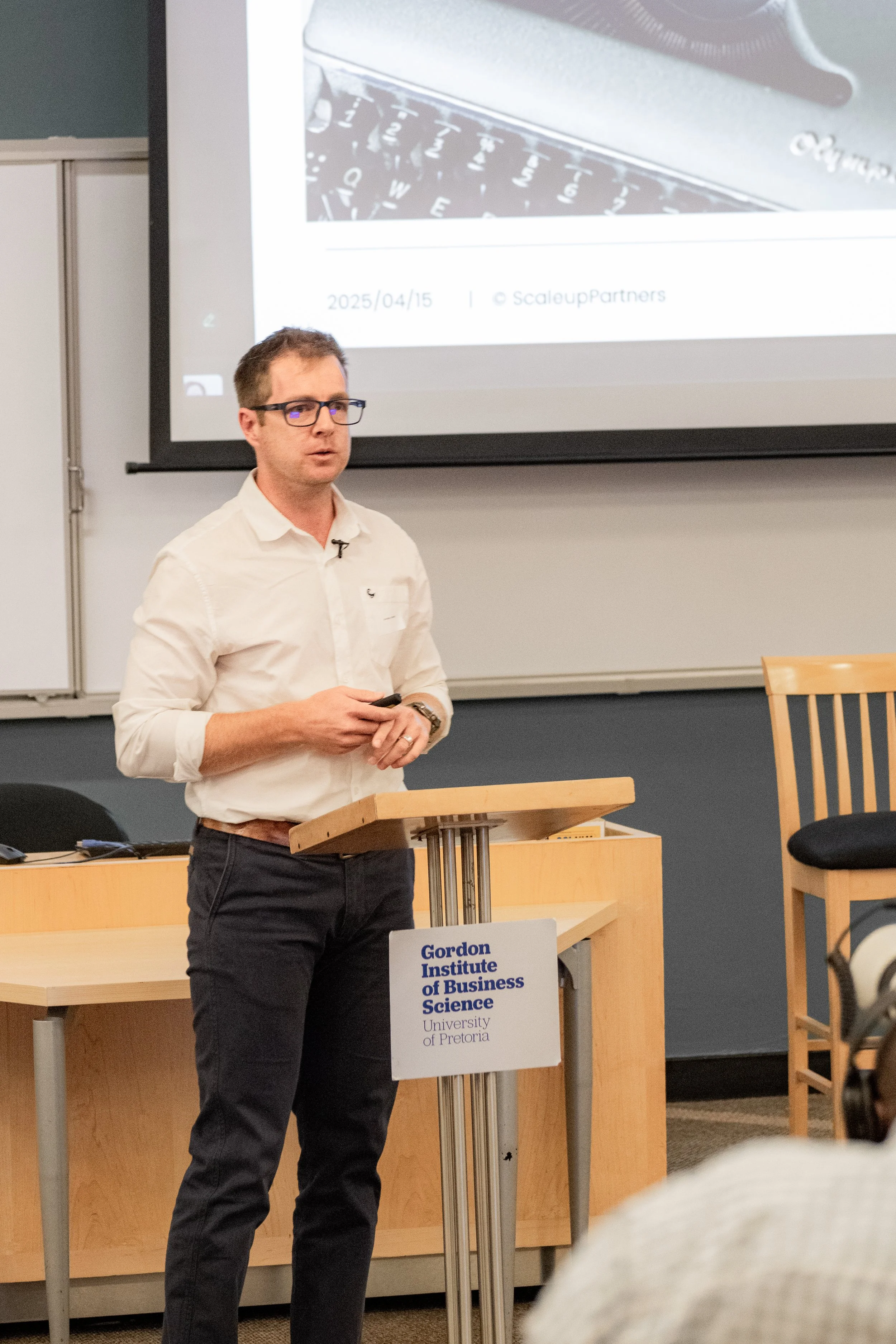 Business speaker delivering a presentation at the Gordon Institute of Business Science, University of Pretoria, during a Scale Up Partners leadership conference in Johannesburg, April 2025