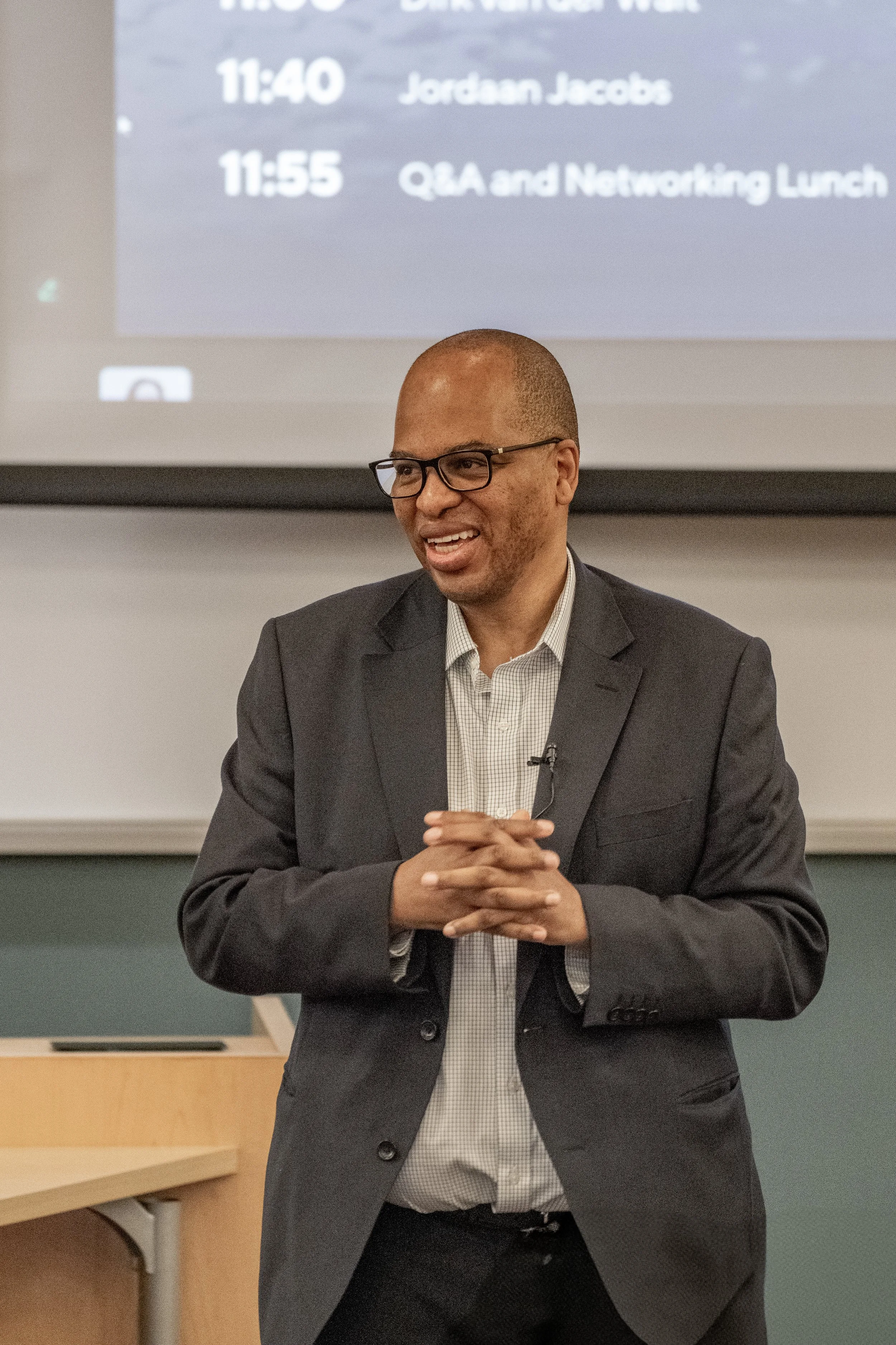 Business speaker addressing attendees in front of a presentation screen at the Scale Up Partners conference in Johannesburg, April 2025