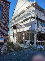 Construction d'un bâtiment avec échafaudage en métal, murs en cours de finition, au début de la construction ou rénovation.