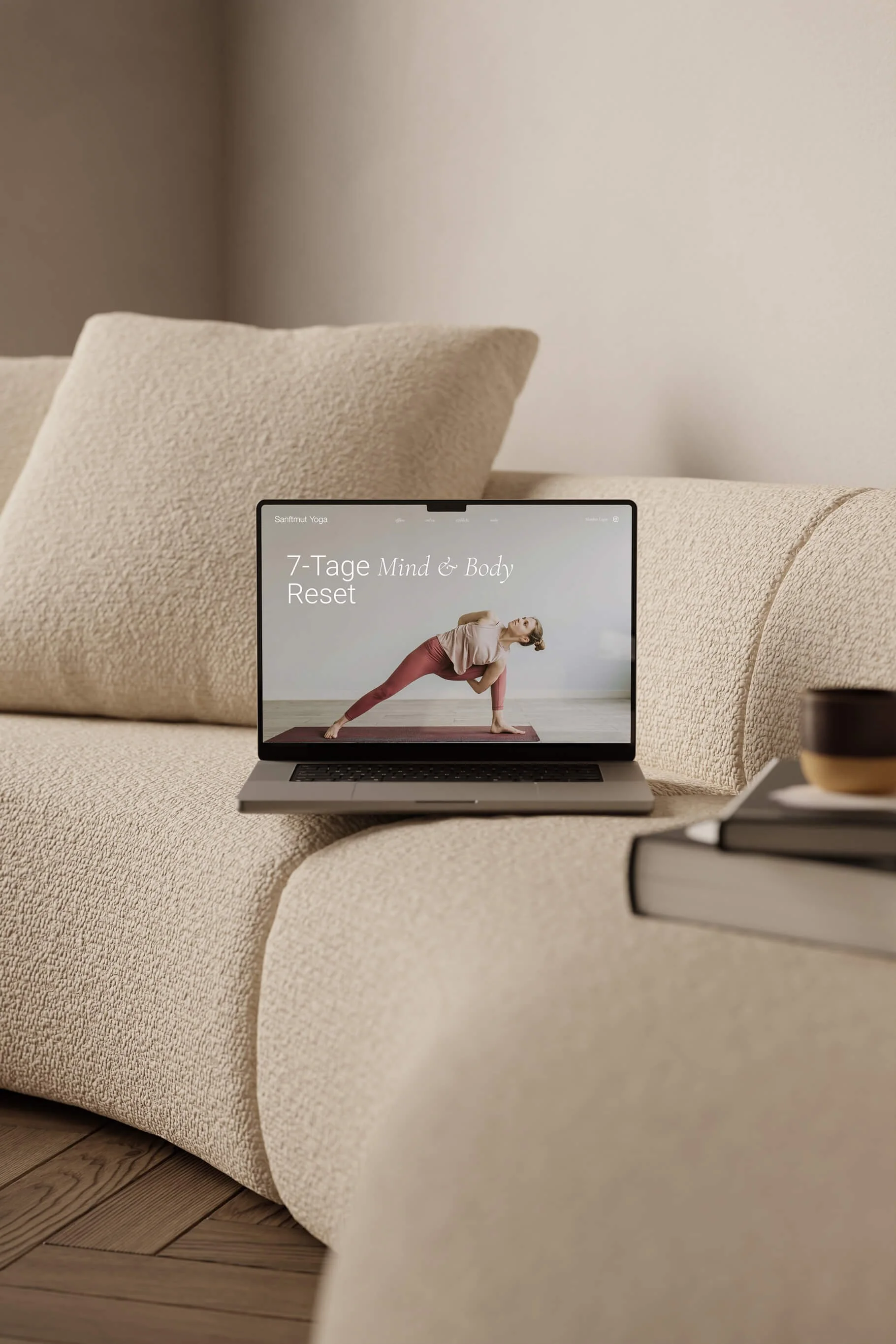 Laptop auf einem Sofa, zeigt eine Yoga-Website, mit Titel '7-Tage Mind & Body Reset'.