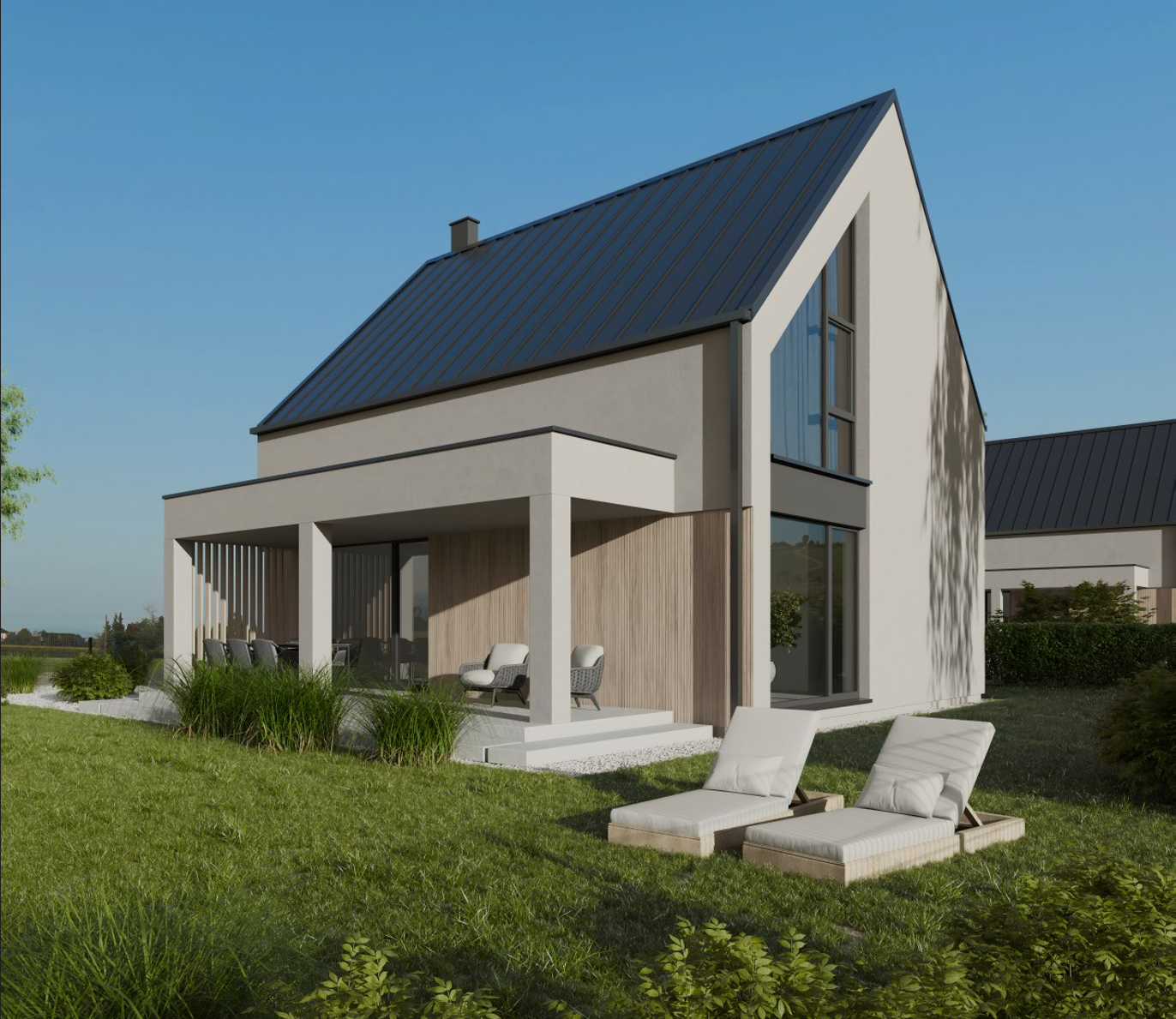Modern white house with a steep black metal roof, large windows, a covered patio with outdoor furniture, and two lounge chairs on a grassy lawn under a clear blue sky.