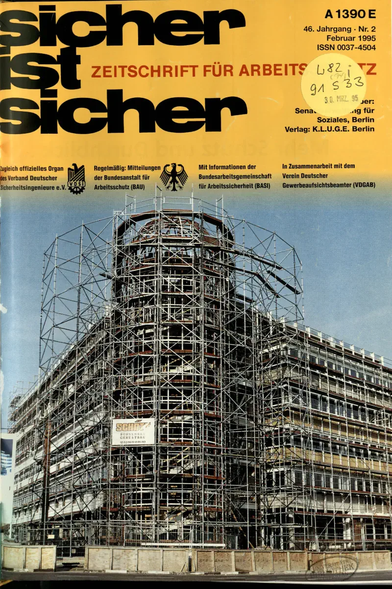 Zeitschrift mit einem Foto eines Gebäudes, das mit Gerüst umgeben ist, wahrscheinlich im Bau oder in Renovierung.