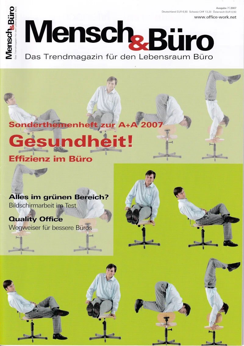 Eine Zeitschrift mit dem Titel "Mensch & Büro" zeigt mehrere Männer in Bürokleidung, die auf Bürohockern verschiedene Yoga-Posen und Haltungen ausführen. Das Cover hebt das Thema Gesundheit und Effizienz im Büro hervor.