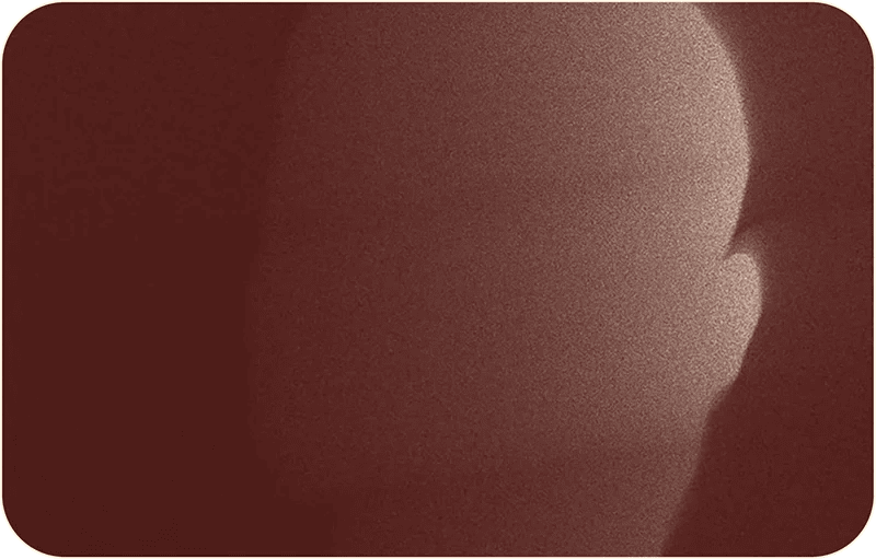 Close-up image of a person's face, partially obscured by shadows.