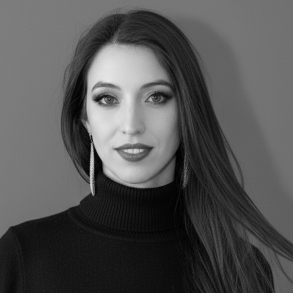Black and white portrait of a woman with long dark hair, wearing a turtleneck sweater and dangling earrings, looking at the camera with a slight smile.